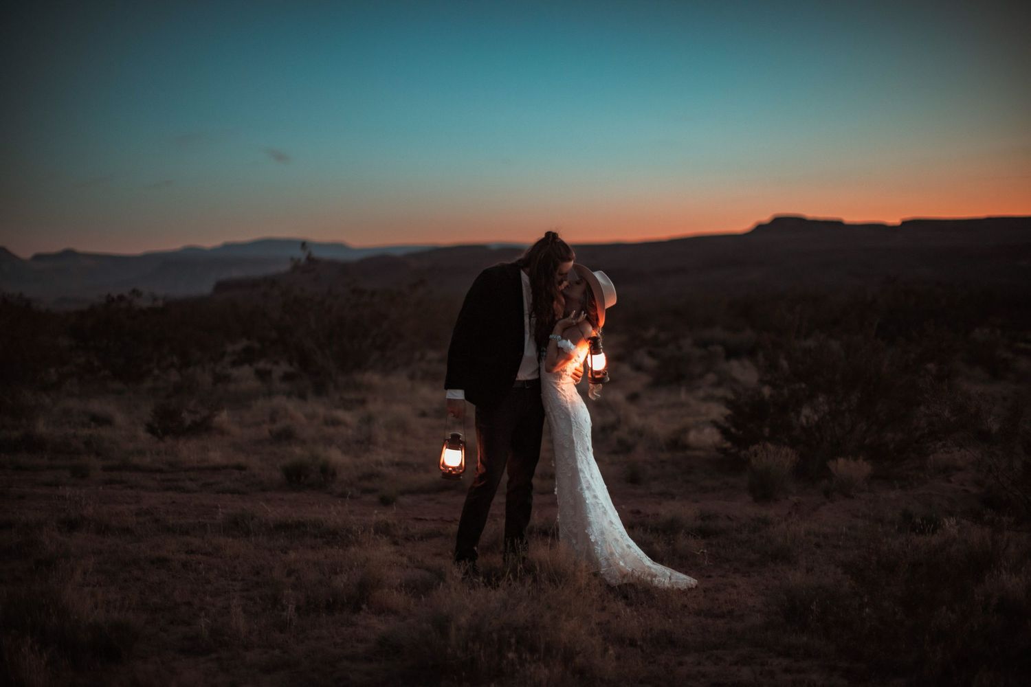 Bride and groom with lanterns at sunset at a desert near Zion National Park in Utah.