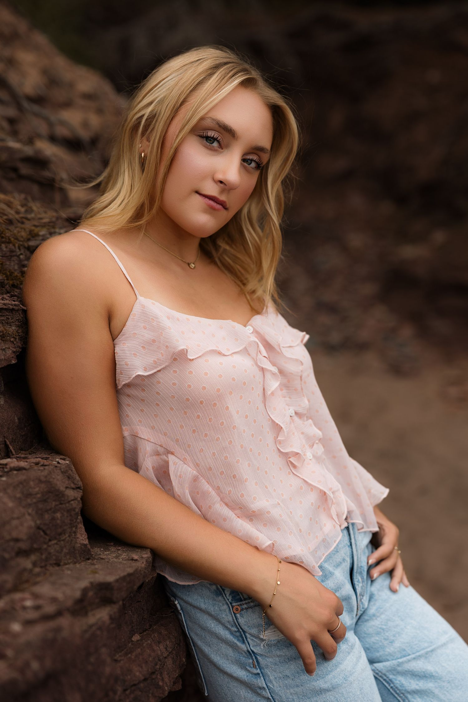 High school senior posing on a beach at Black Rocks on Preque Isle in Marquette, Michigan.