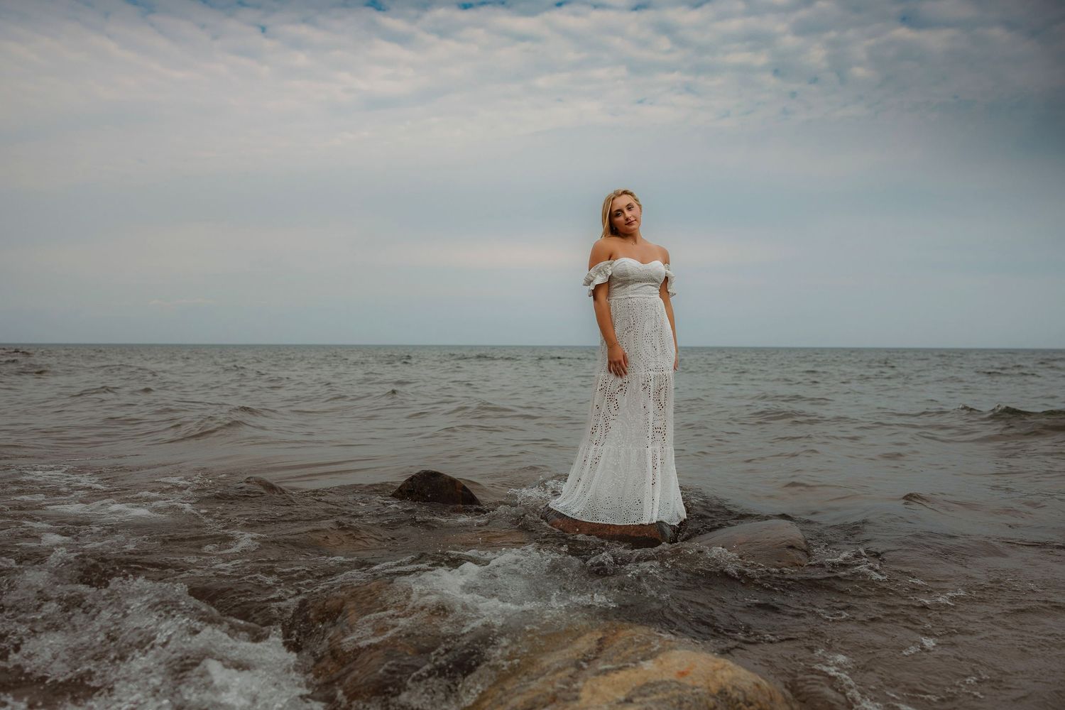 High school senior posing on a beach at Wetmore Landing in Marquette, Michigan.