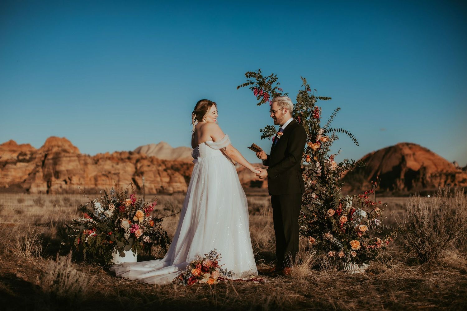 Bride and groom exchange vows during elopement at sunset at a desert near Zion National Park in Utah.