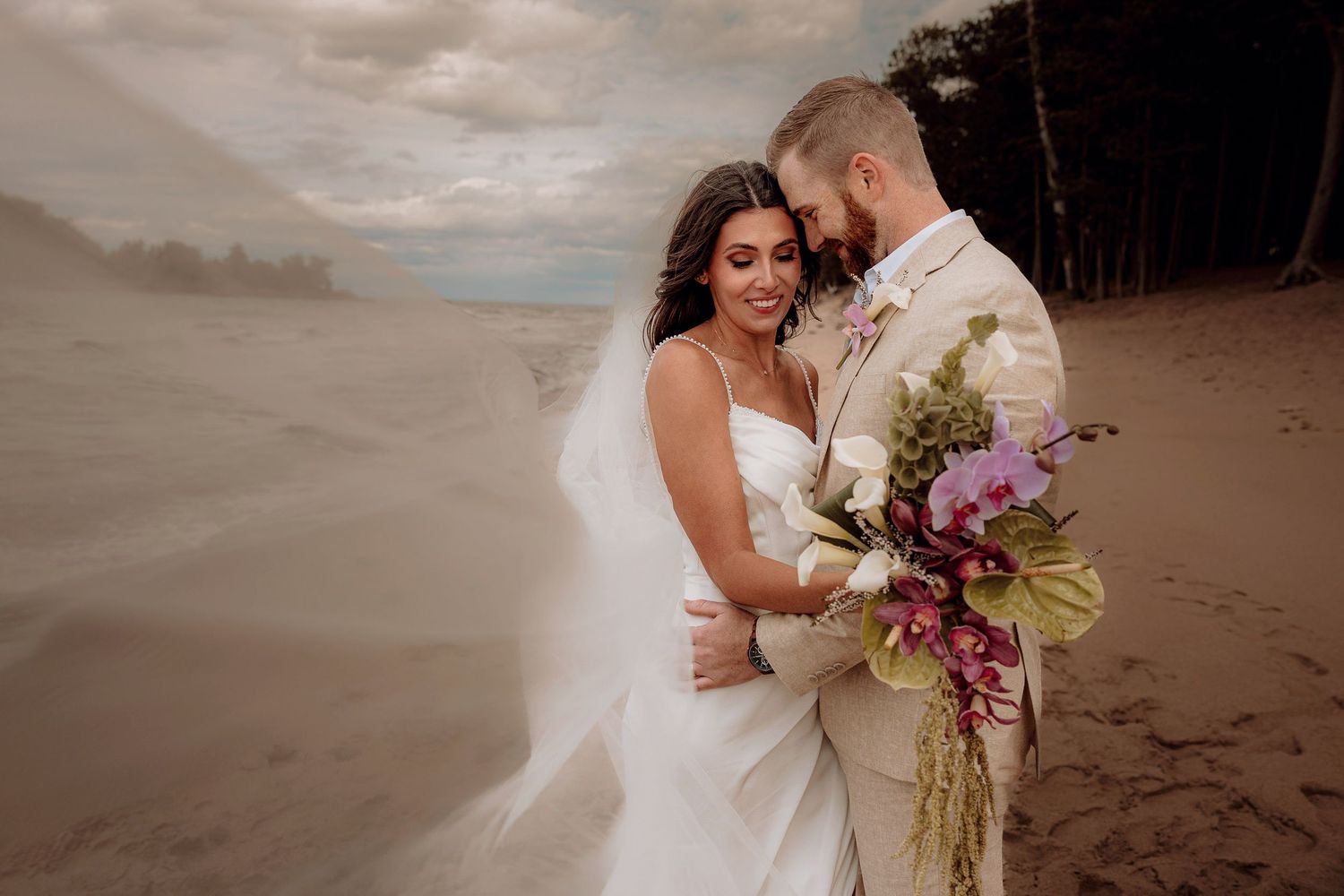 Bride and groom running on the beach following their elopement at Little Presque Isle in Marquette, Michigan, romantic beach ceremony
