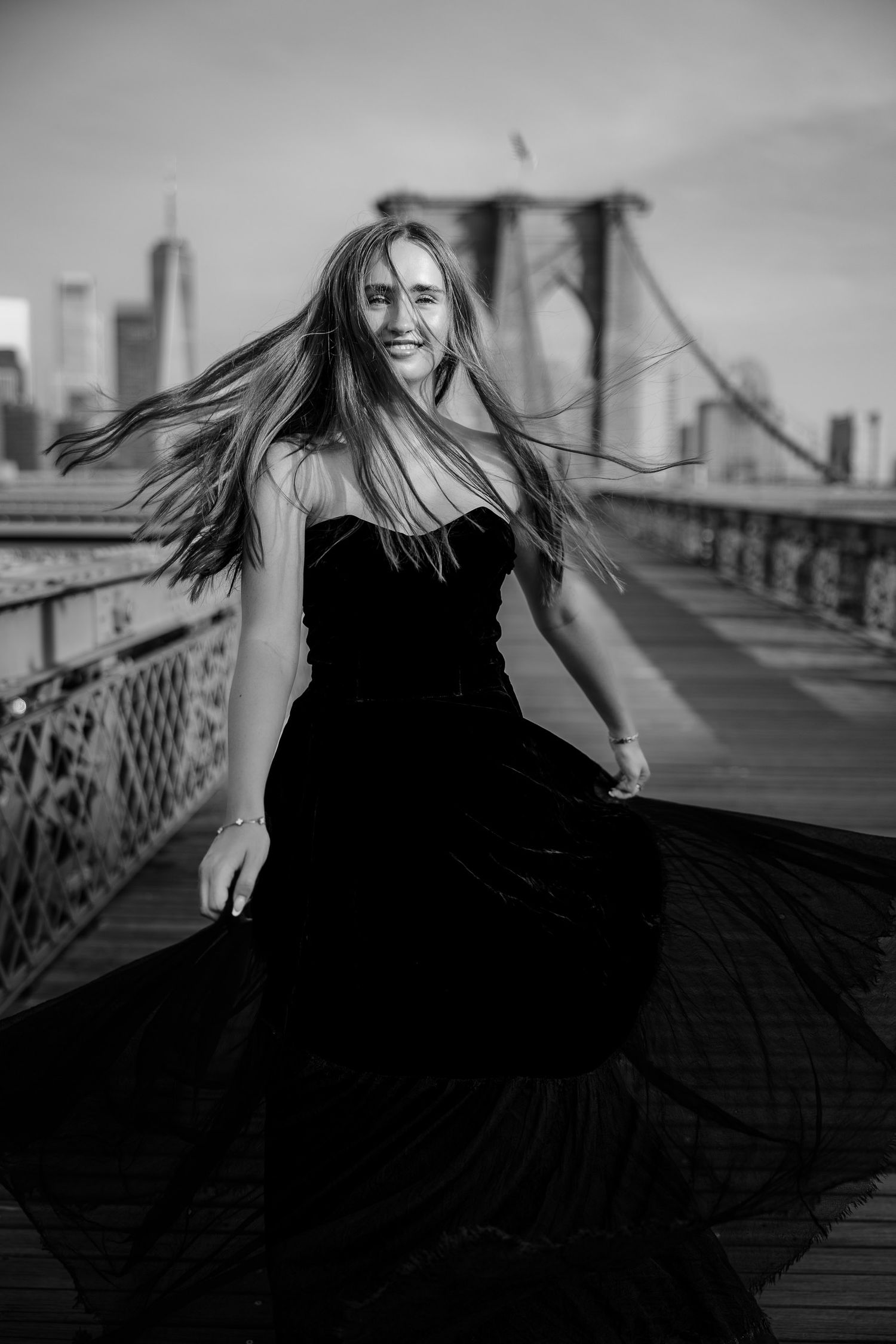 Senior portrait on the Brooklyn Bridge in New York City with the skyline in the background.