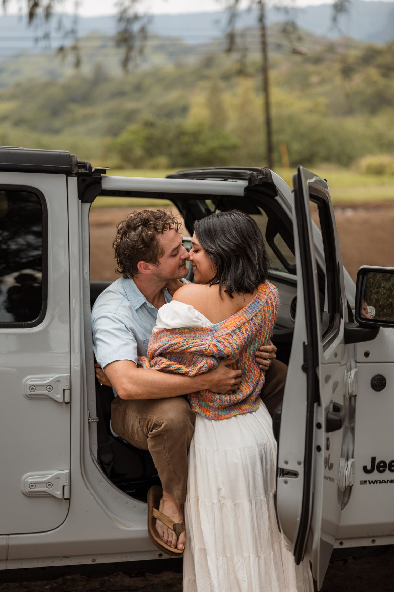 Engagement couple kissing on the beach with a jeep in kauai, Hawaii. Elopement photographer, destination.
