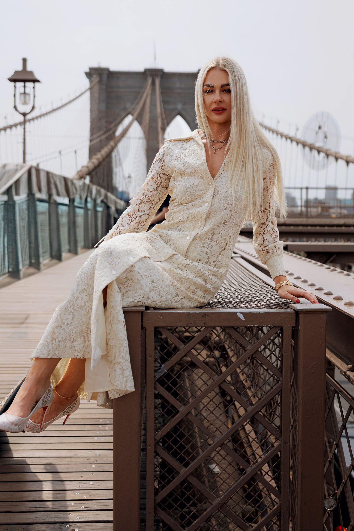 Bride in vintage dress sitting on a bridge with designer shoes. Old New York wedding meets Marquette MI bride. Bride is a model in NYC