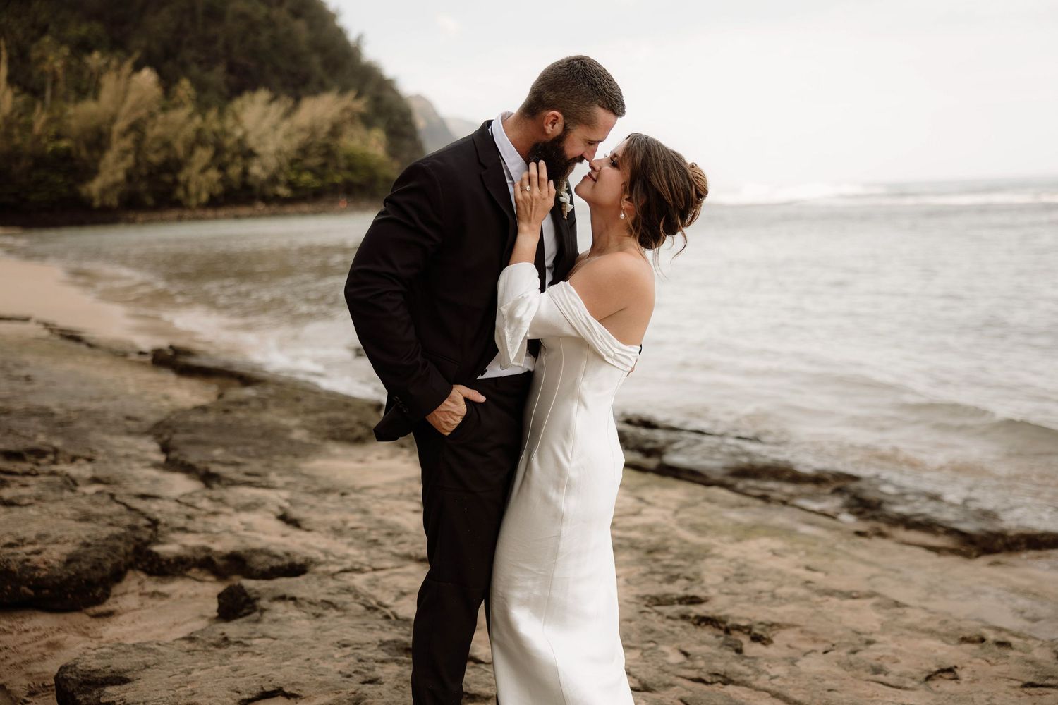 Bride and groom sharing kiss after their elopement on the Na Pali coast in Kauai, Hawaii.