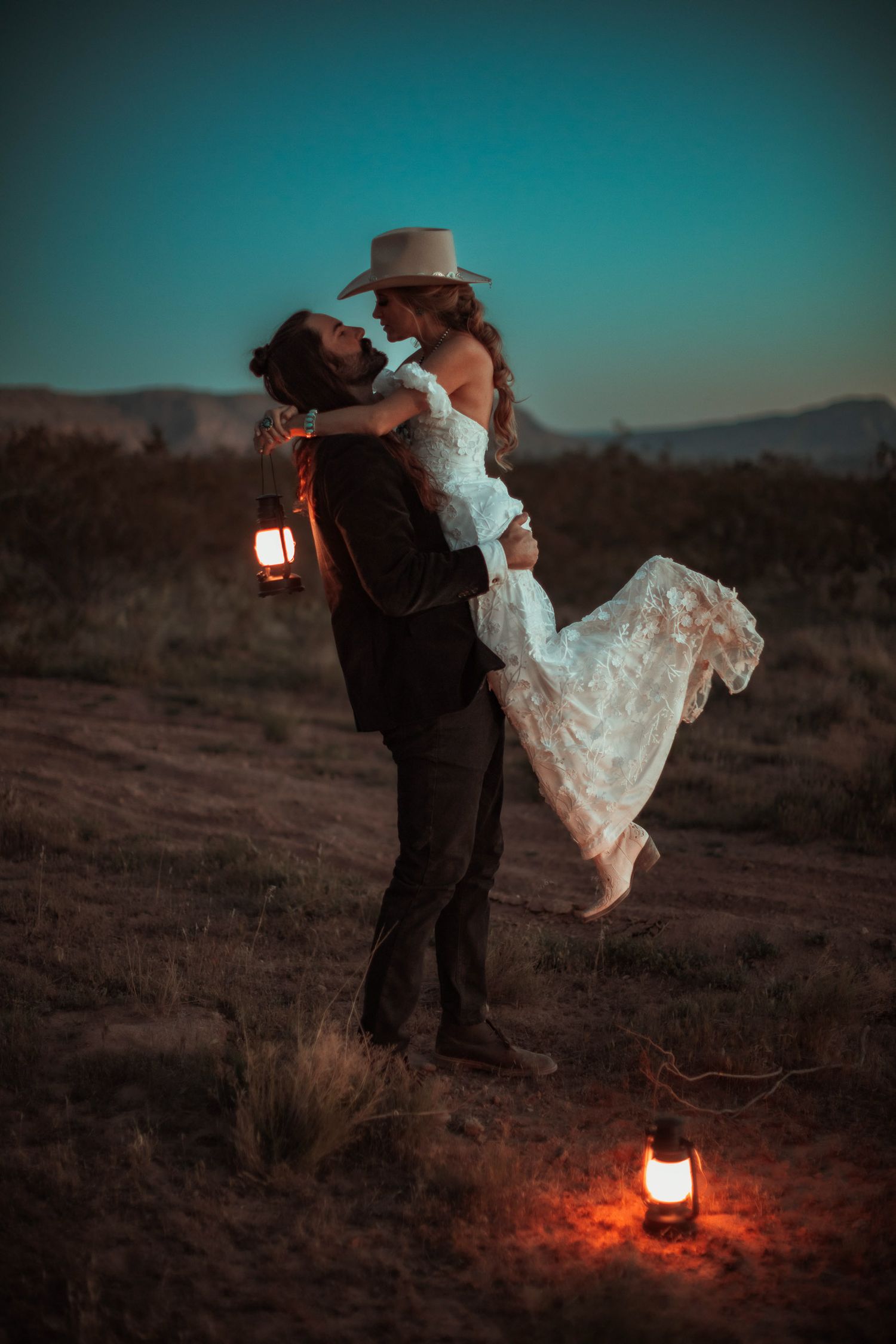 Bride and groom with lanterns at sunset at a desert near Zion National Park in Utah.