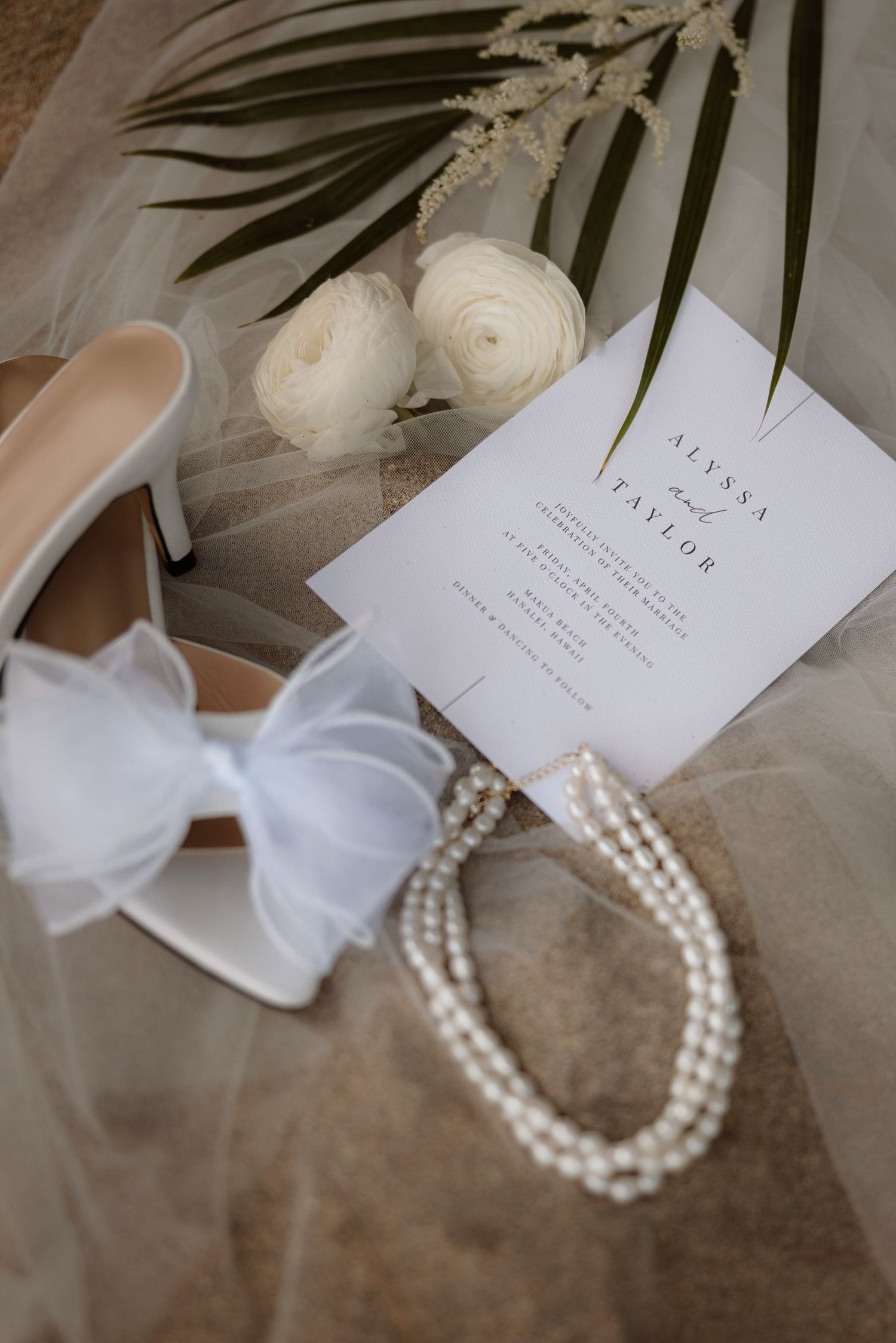 Detail on a beach with shoes, pearls and flowers on the Na Pali coast in Kauai, Hawaii.