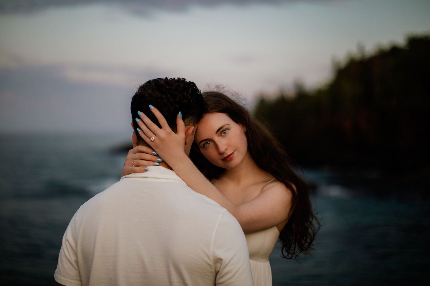 Engagement pictures with lanterns at sunset on Black Rocks in Marquette, Michigan. Girl holding mans head