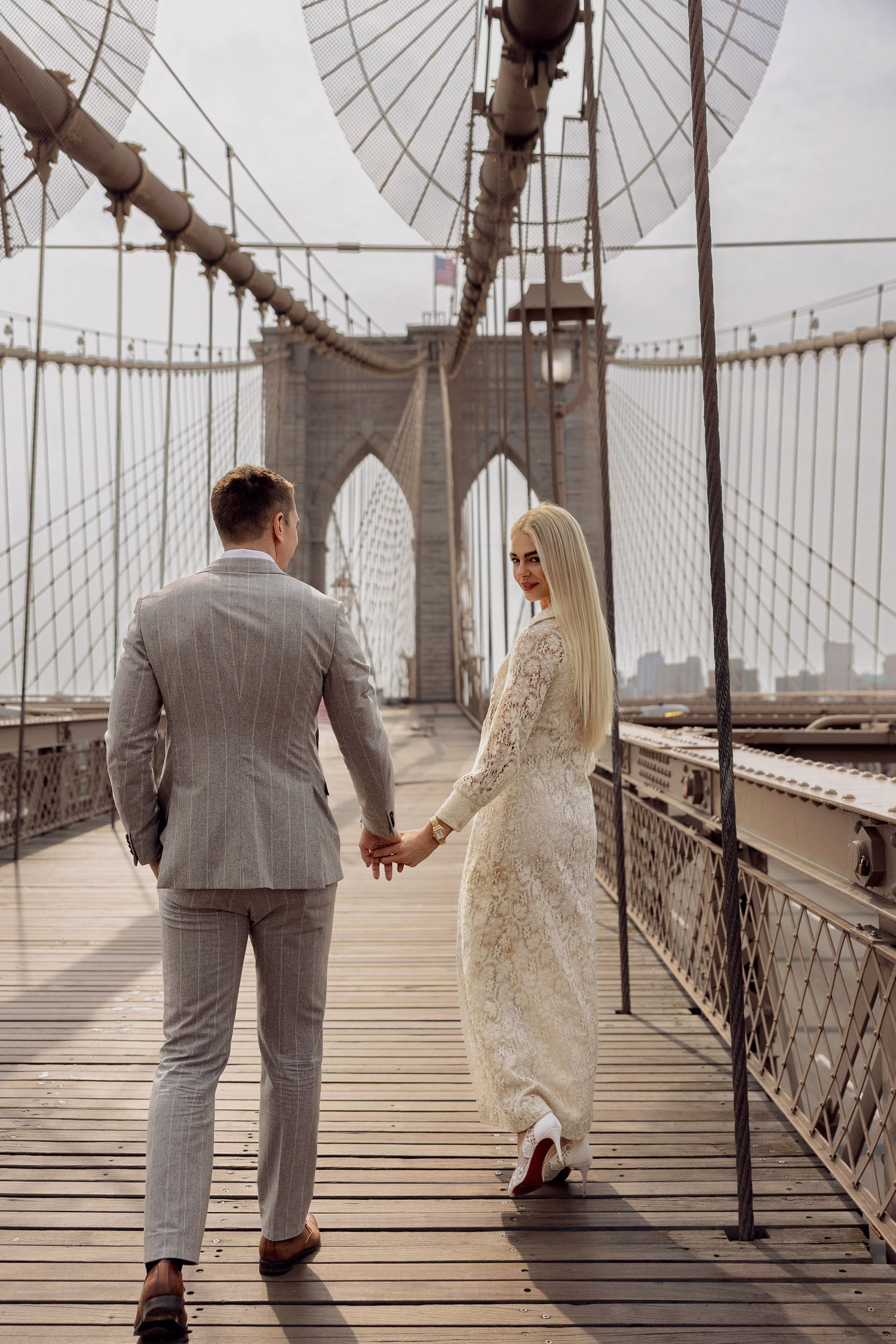 Bride and Groom on the Brooklyn bridge after their elopement in New York City with the skyline in the background.