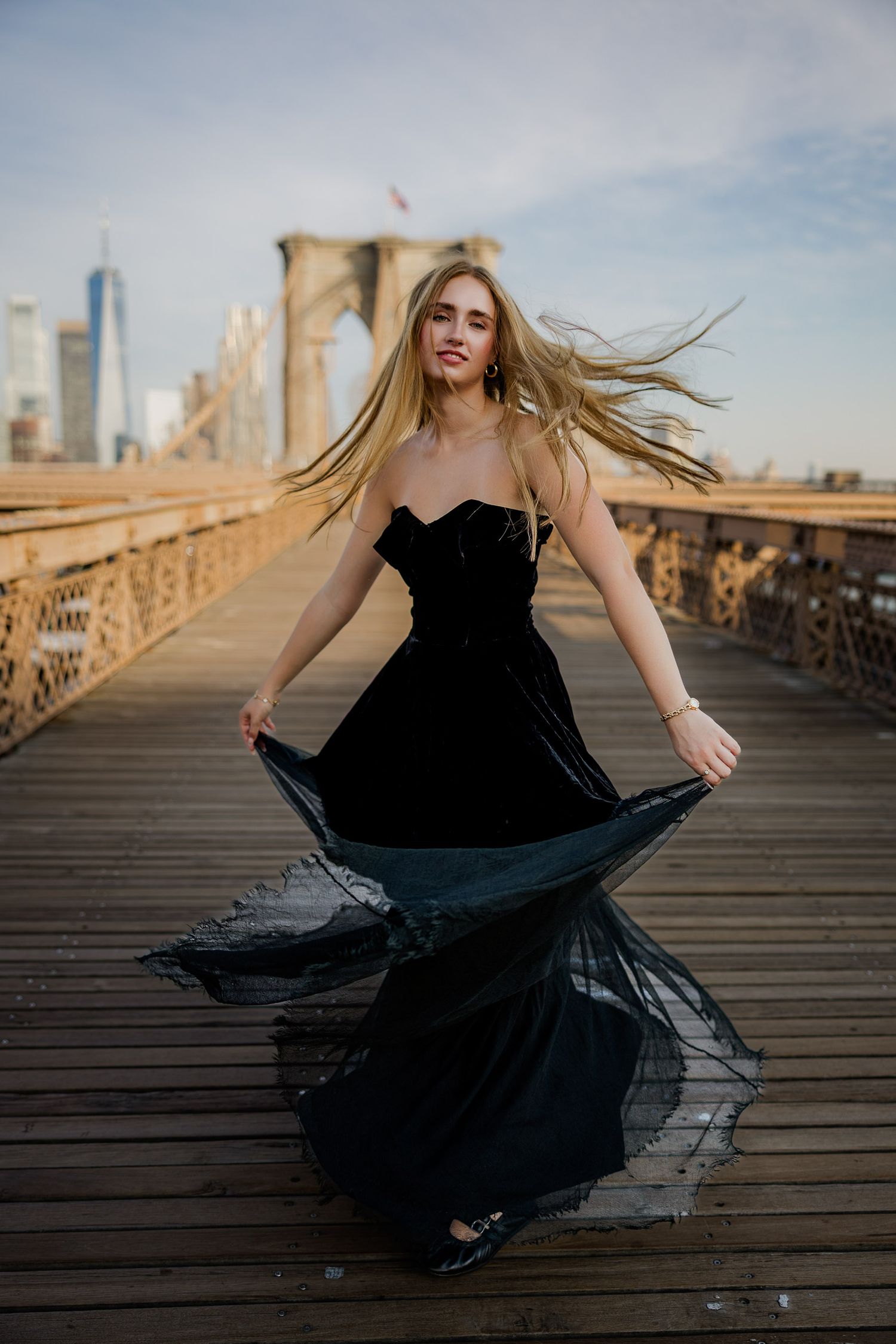 Senior portrait on the Brooklyn Bridge in New York City with the skyline in the background.