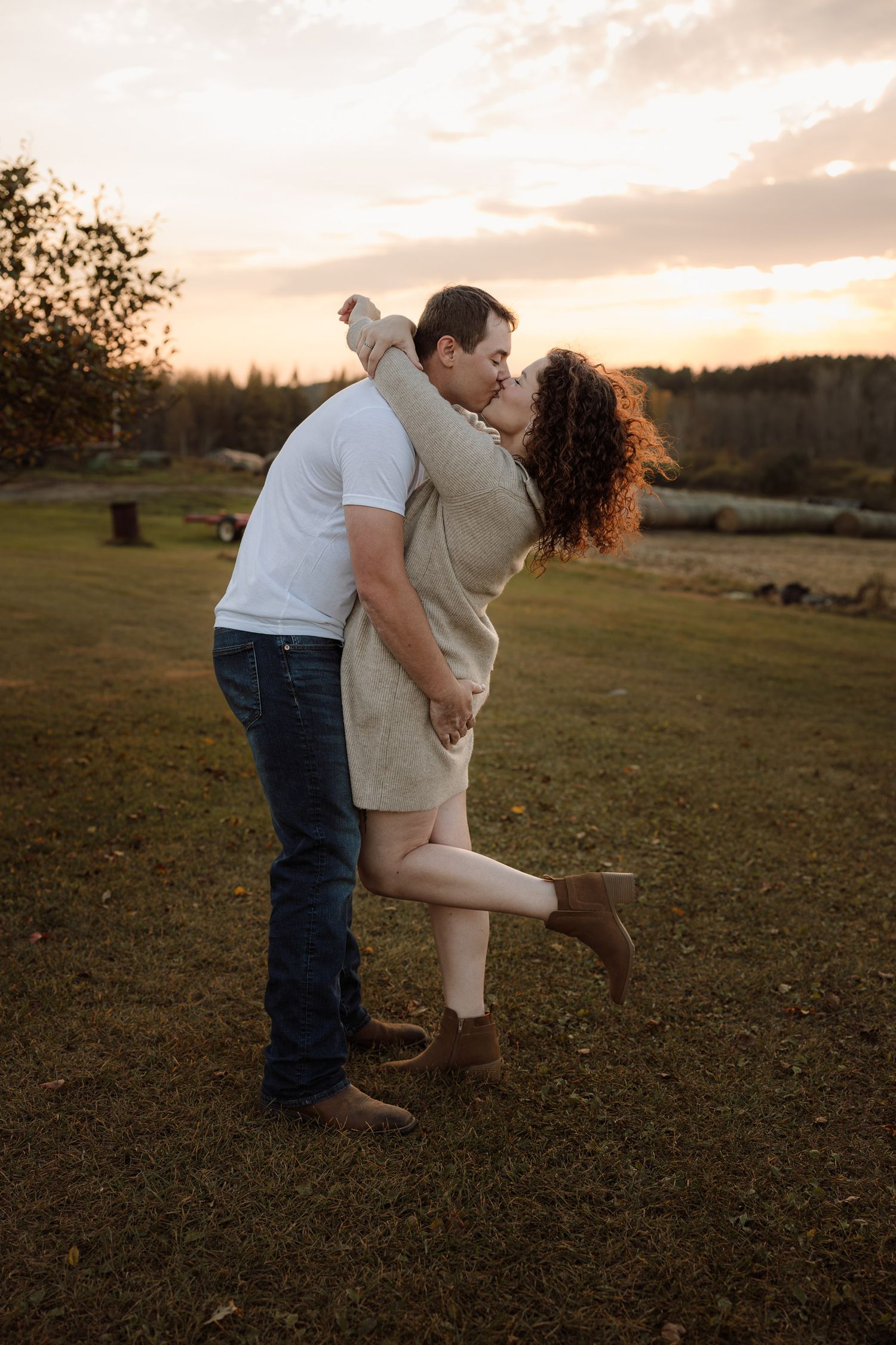 Sunset engagement pictures in a field with apple trees Marquette, Michigan.
