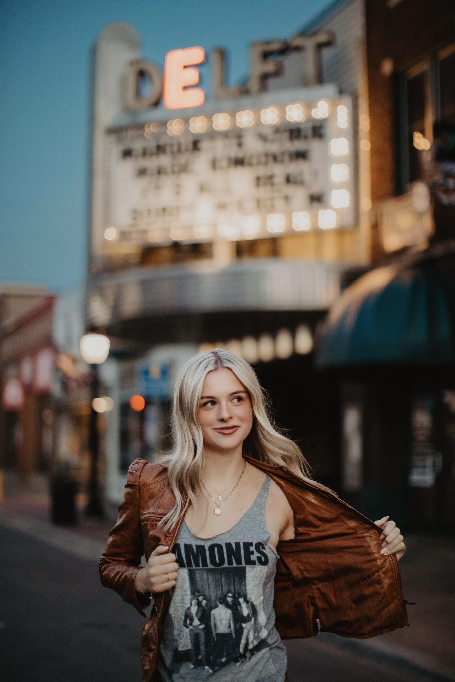 high school senior portraits girl sitting on a busy street leather coat Marquette mi, Escanaba, NYC, Green Bay the best senior photographer