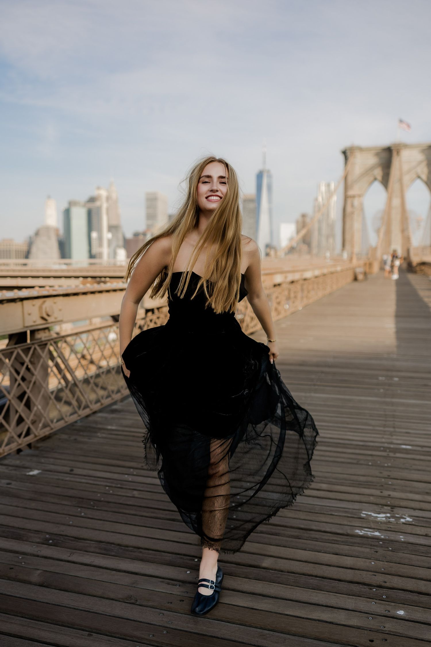 Senior portrait on the Brooklyn Bridge in New York City with the skyline in the background.