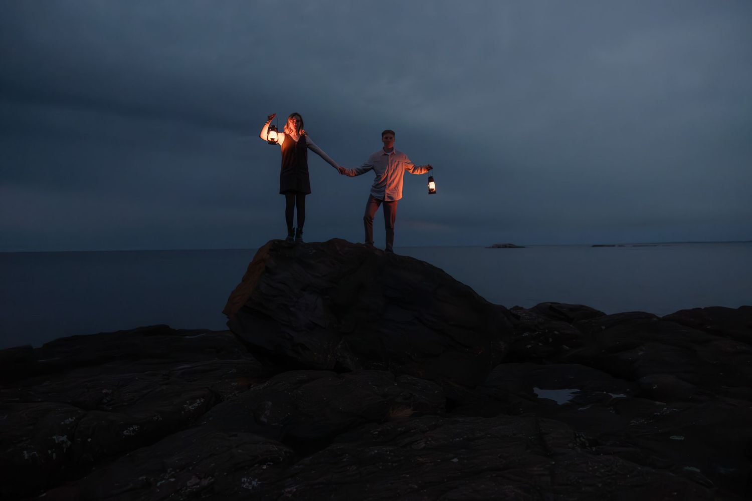 Engagement pictures with lanterns at sunset on Black Rocks in Marquette, Michigan.