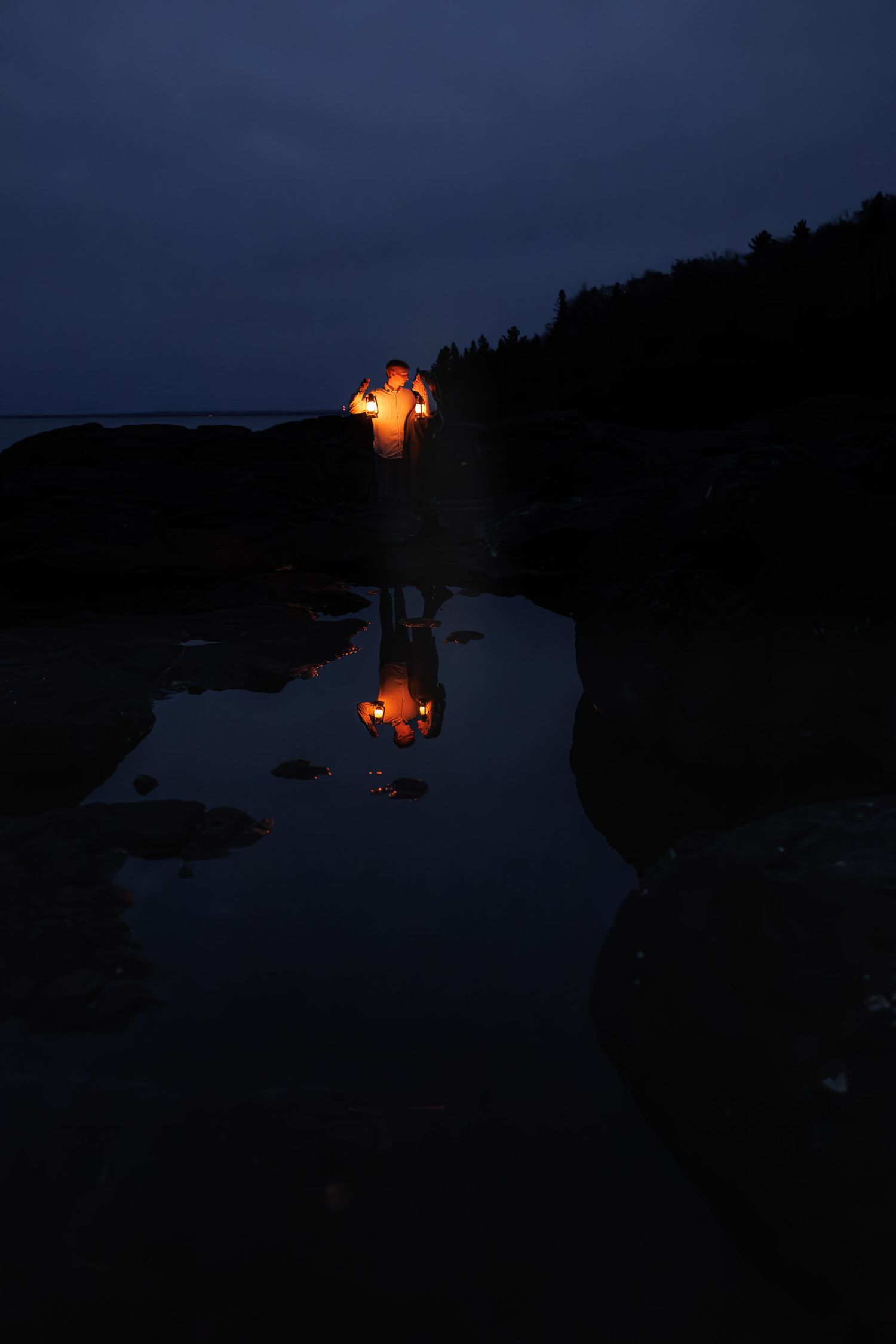 Engagement pictures with lanterns at sunset on Black Rocks in Marquette, Michigan.
