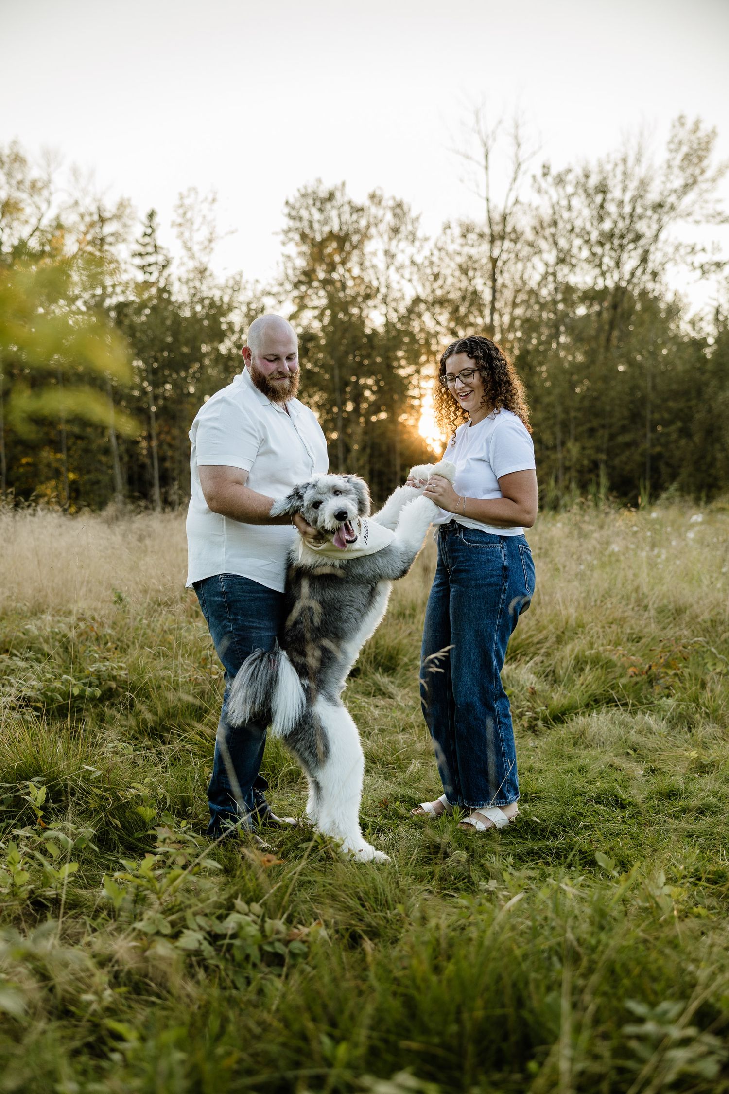 Engagement pictures with dog in a field by a beach in Escanaba, Michigan