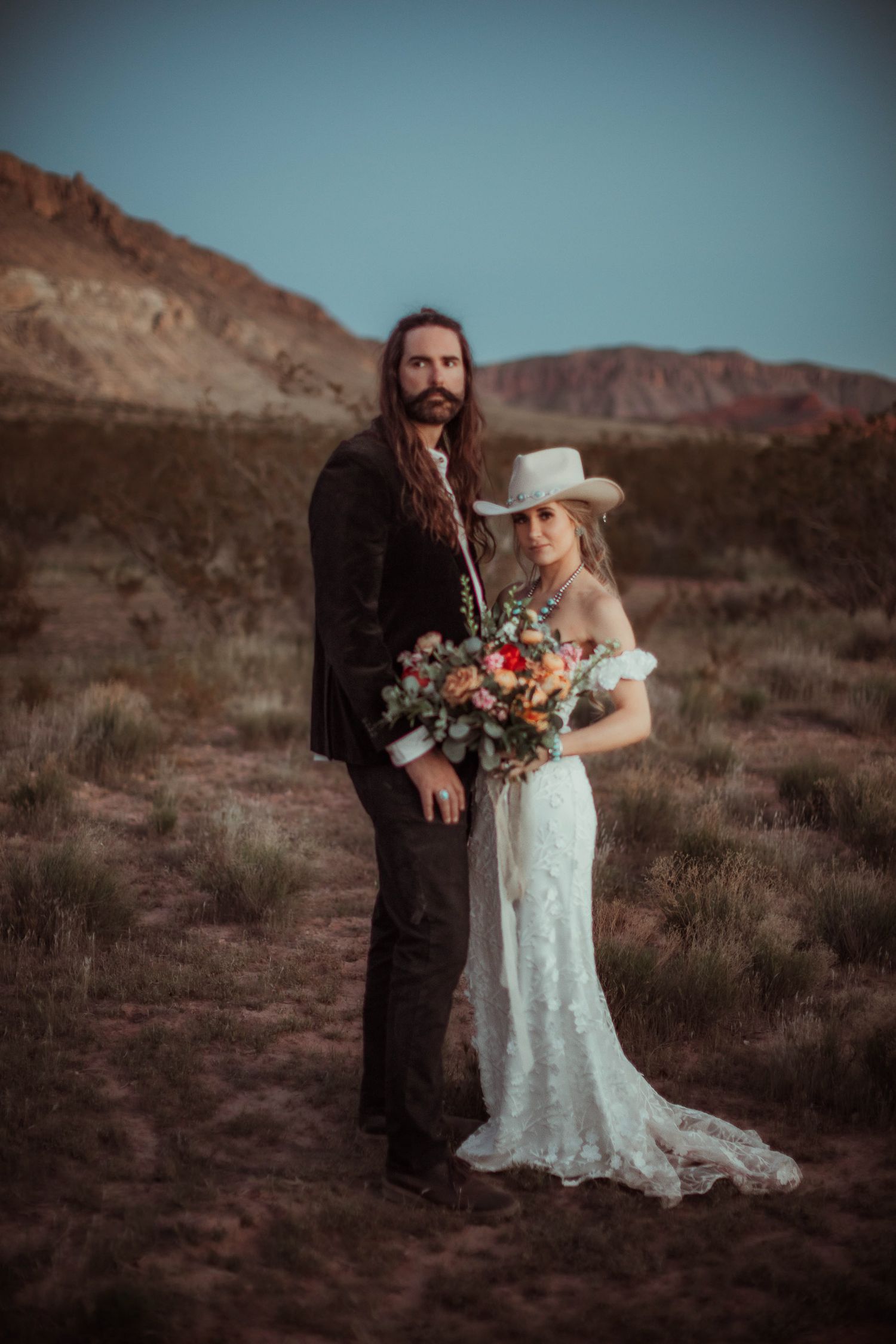 Bride and groom with lanterns at sunset at a desert near Zion National Park in Utah.