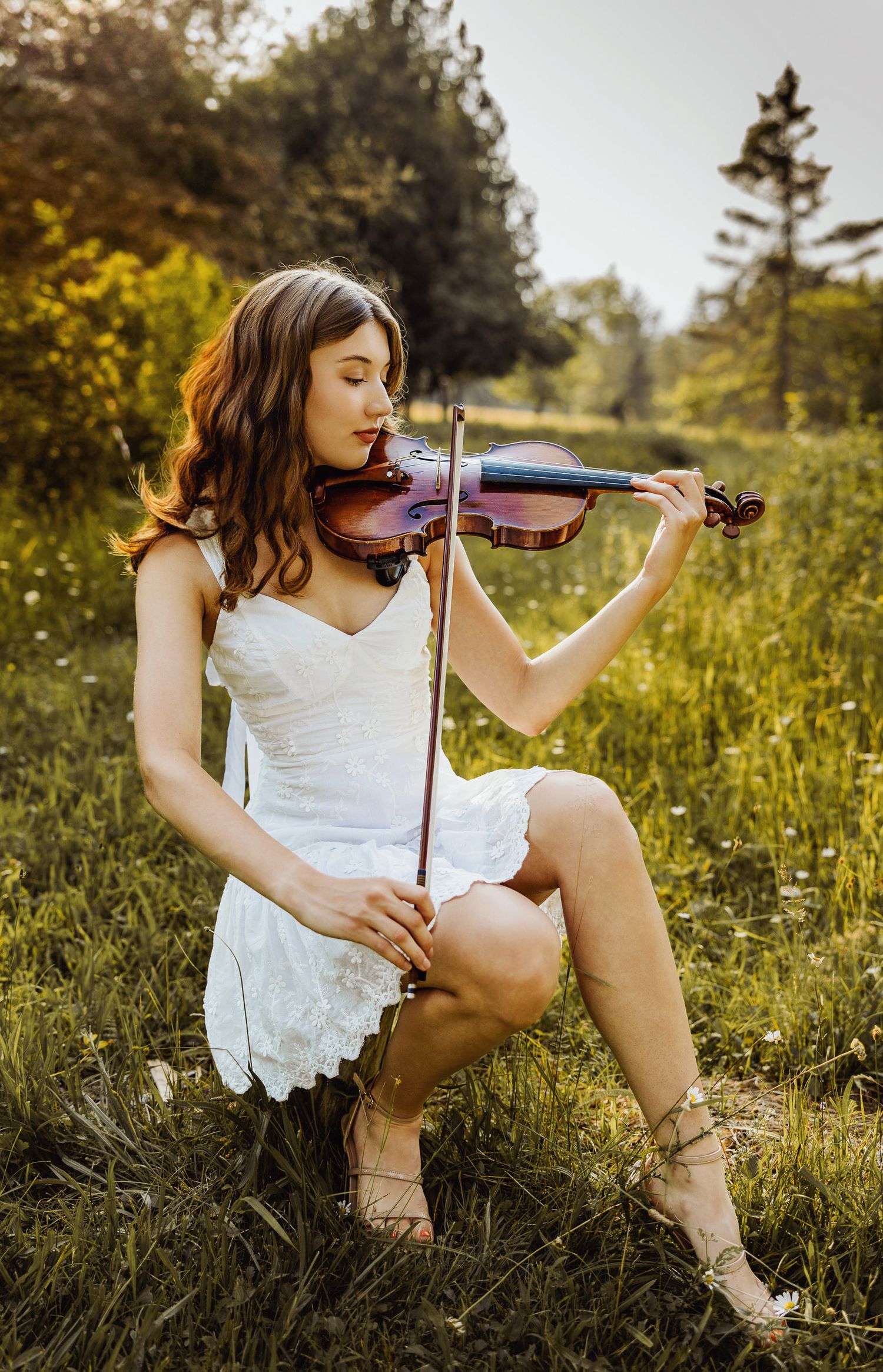High school senior during golden hour in a field in plain an instrument Marquette, Michigan.