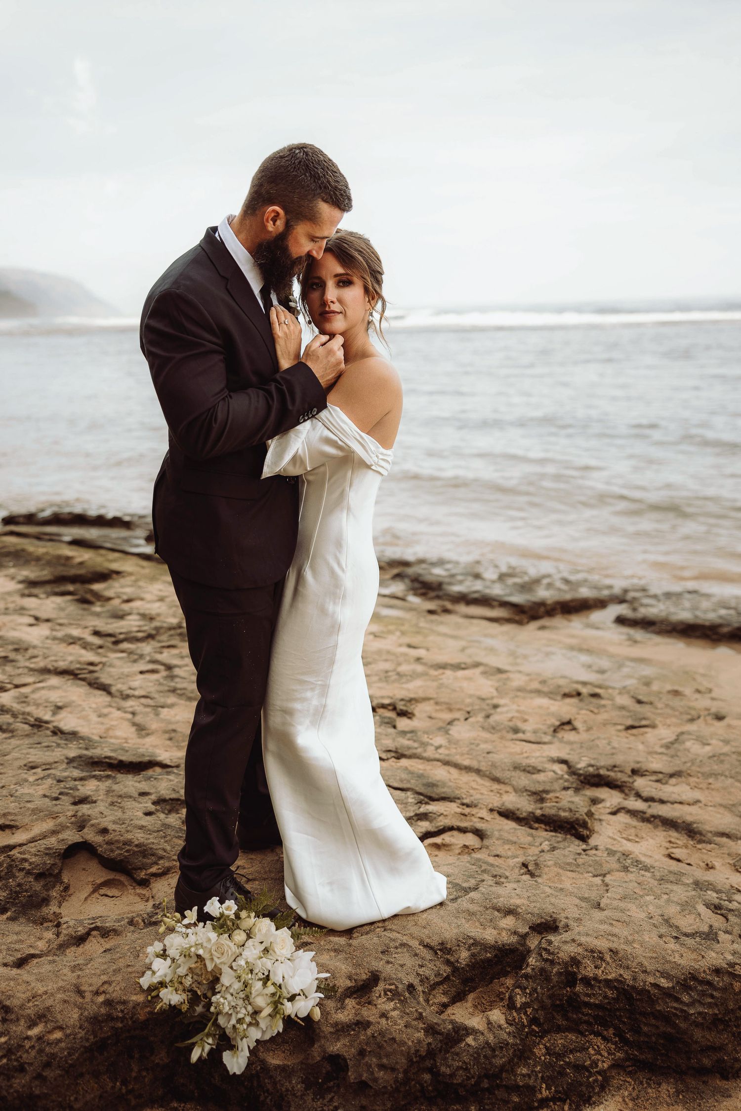 Bride and groom sharing kiss after their elopement on the Na Pali coast in Kauai, Hawaii.