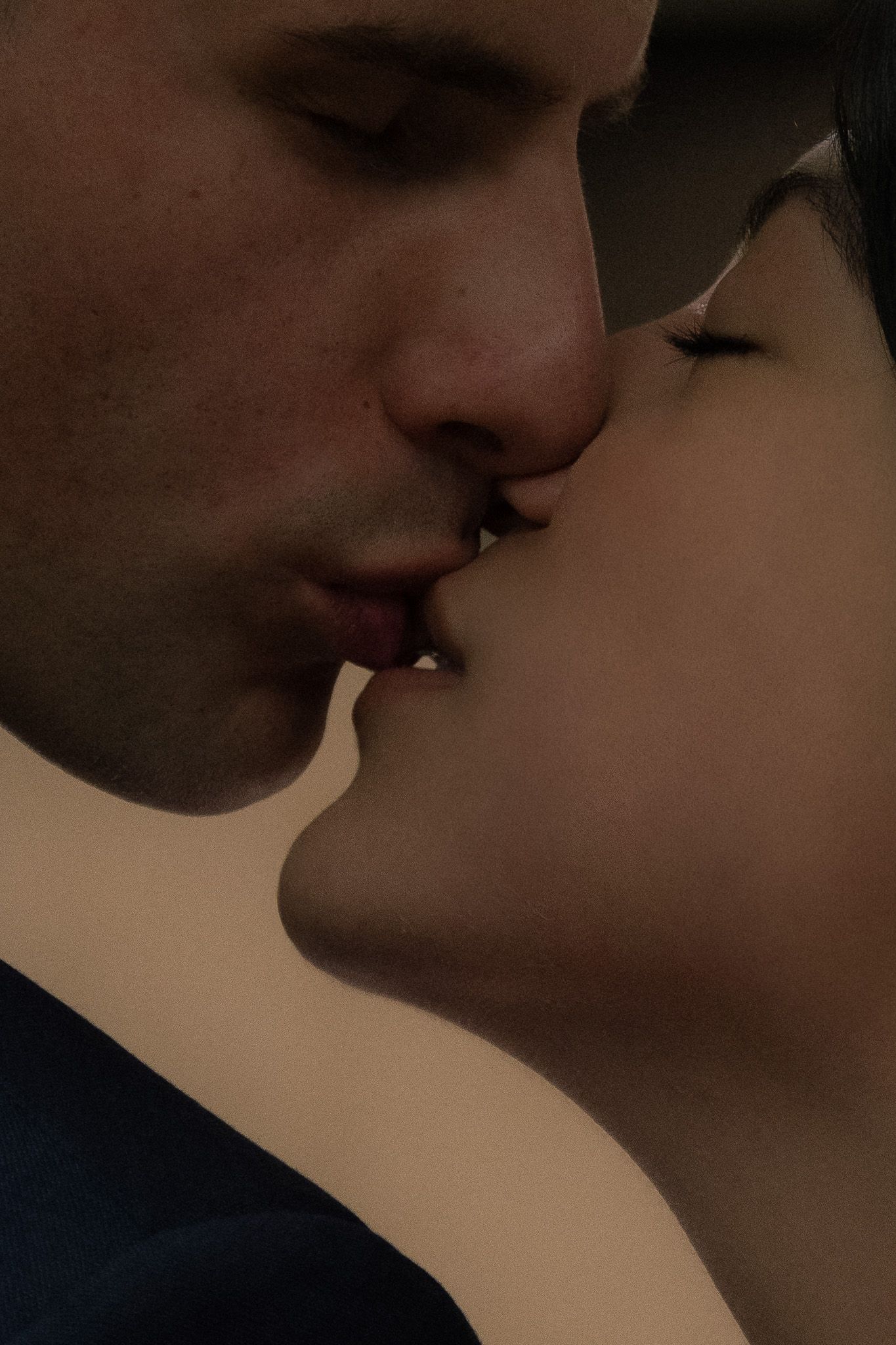 Intimate close-up of a tender romantic moment in warm lighting.