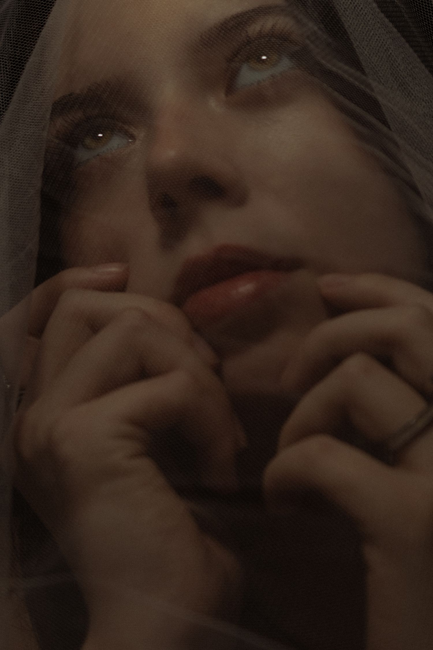 A series of dark, moody close-up portraits showing different facial expressions in low lighting conditions.