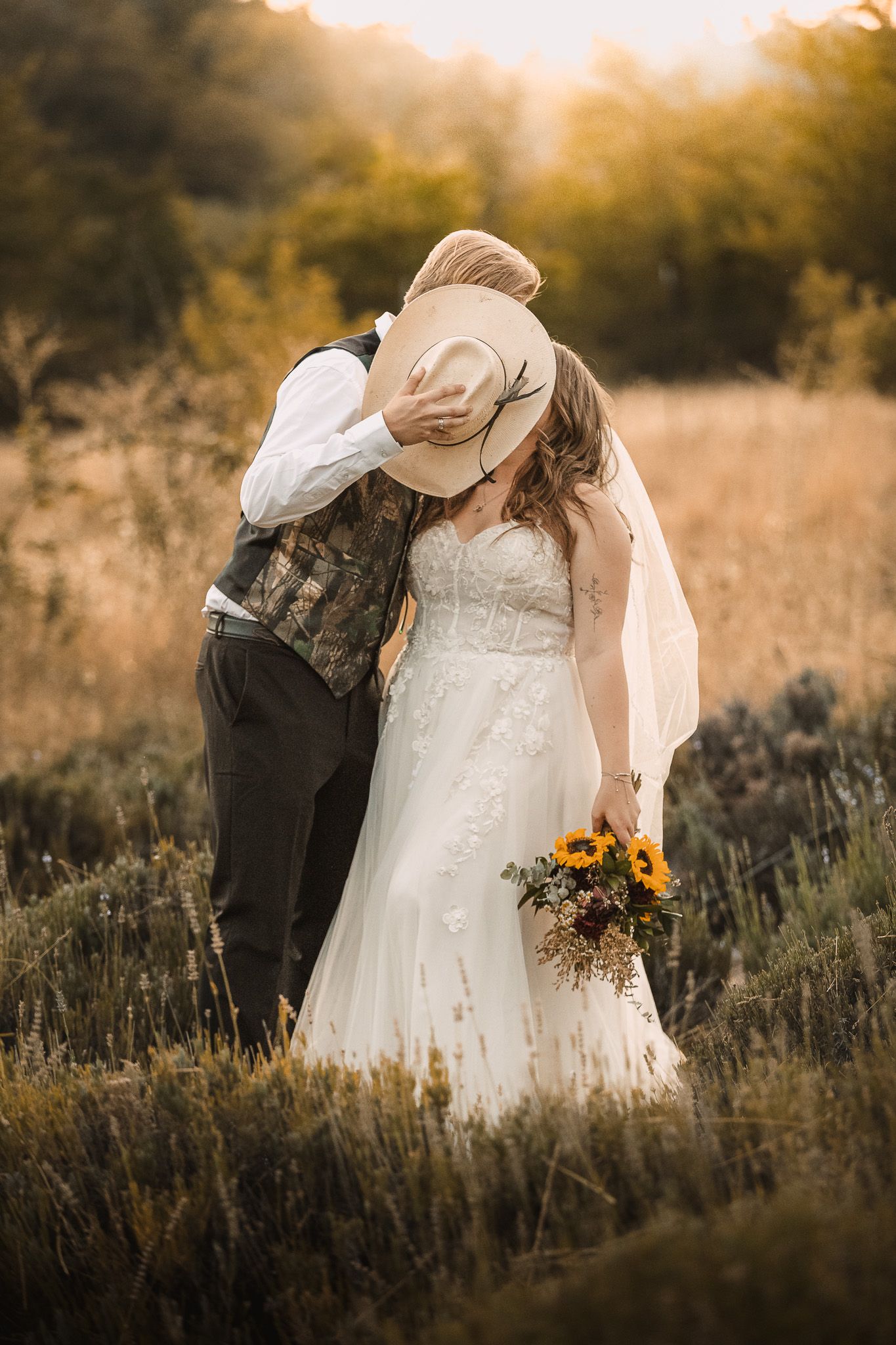 Romantic sunset wedding portrait in a field of wild sage and sunflowers.
