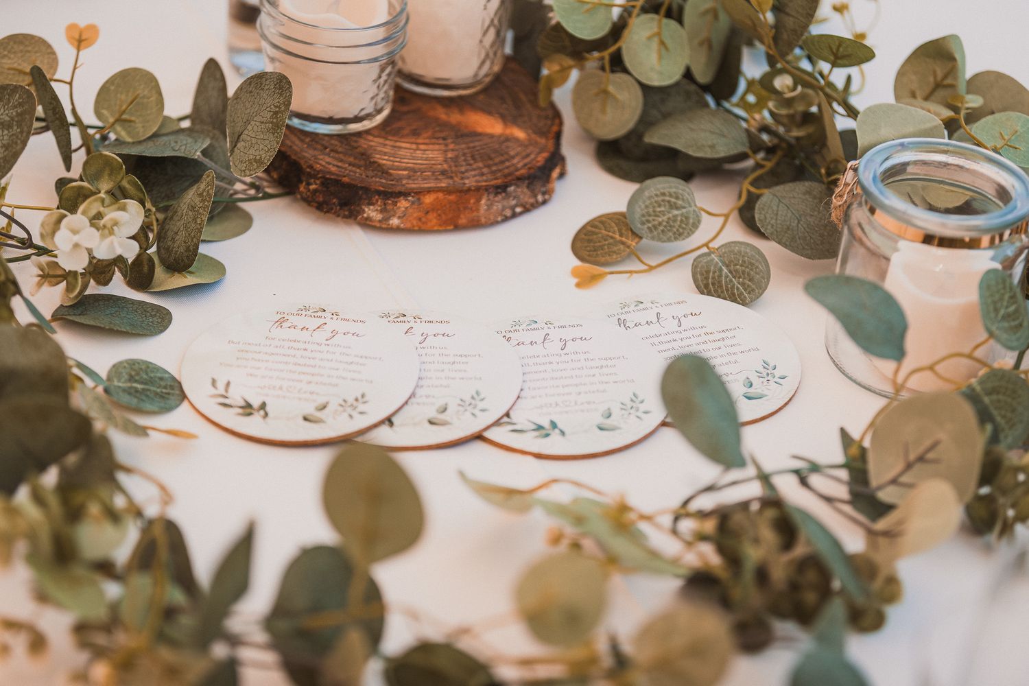 Delicate table settings with eucalyptus leaves and vintage-style place settings.