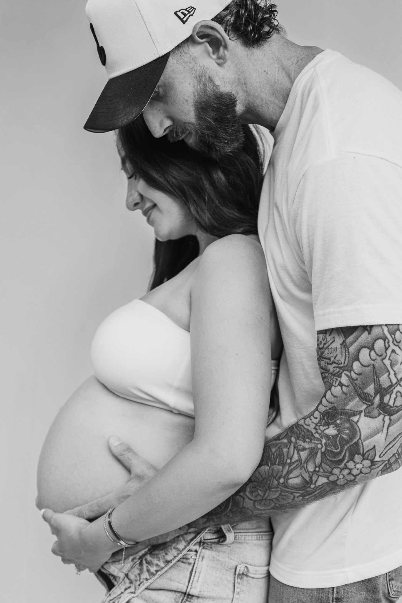Black and white photo sequence showing a couple embracing in a tender moment wearing white t-shirts.