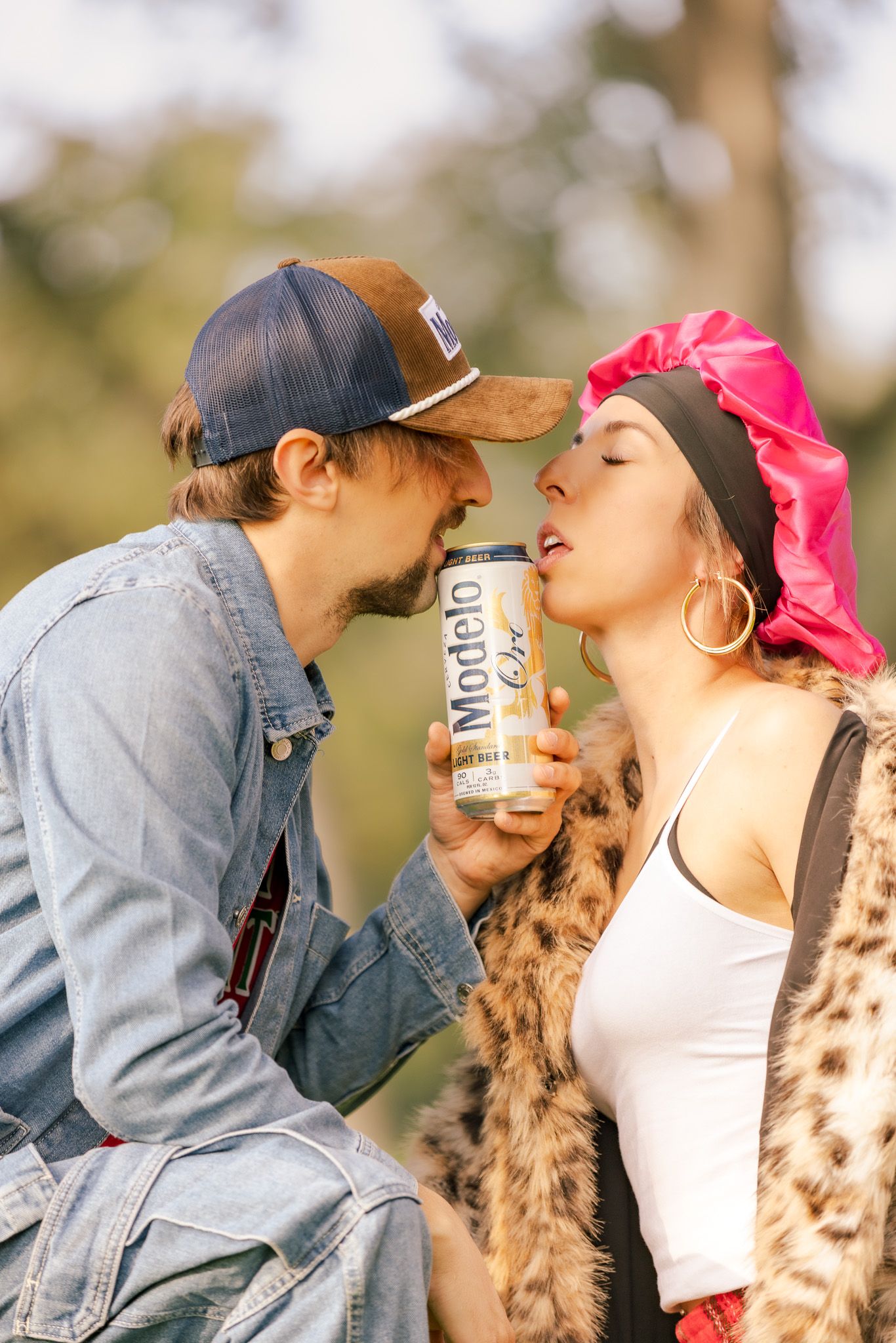 A couple shares a playful moment outdoors with their Australian Shepherd dog.