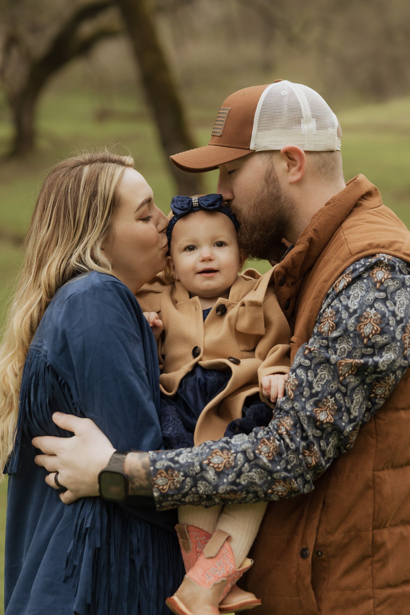 Family sharing tender moments together outdoors on a fall day wearing coordinated navy and brown outfits.