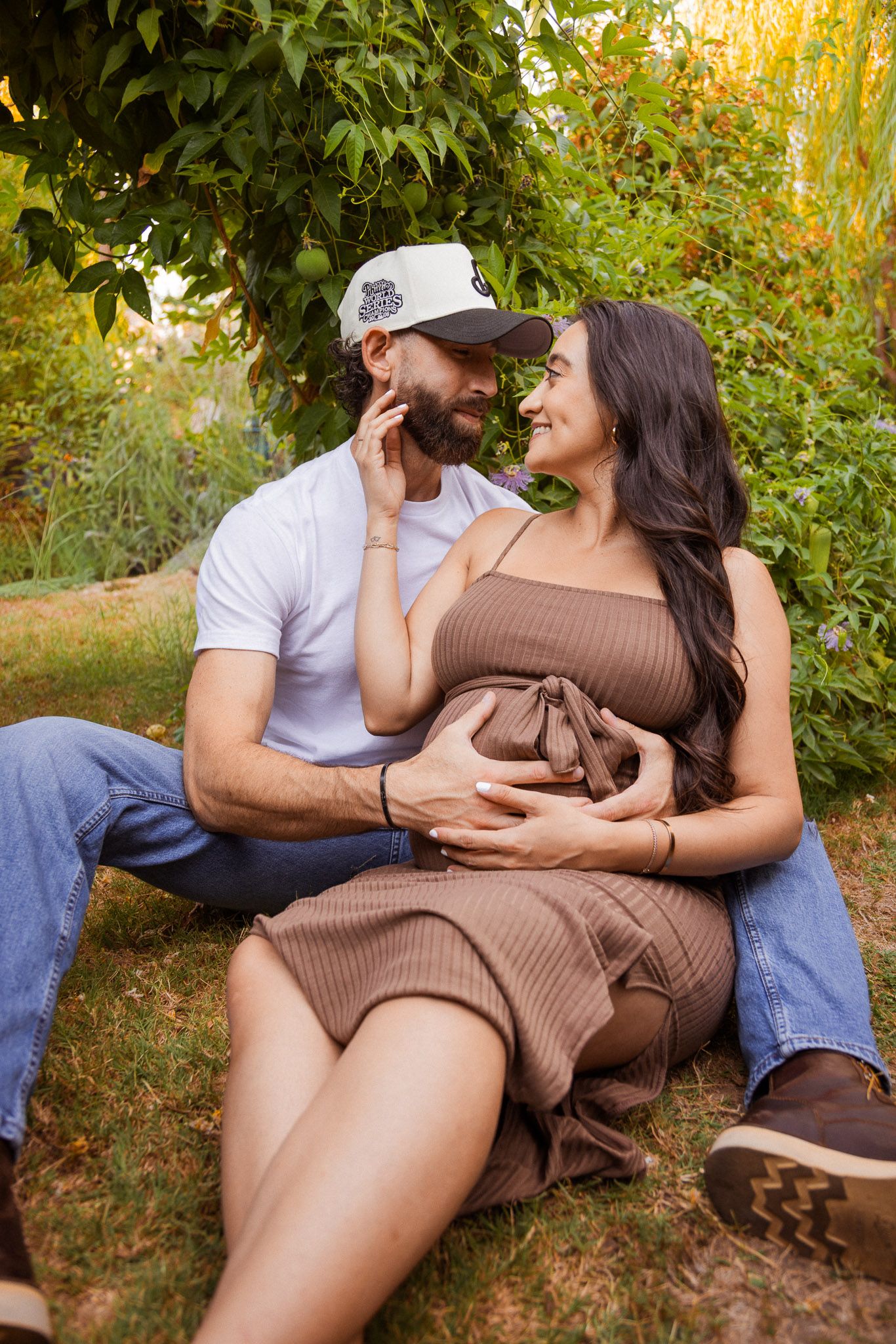 Romantic couple sharing tender moments on outdoor bench surrounded by fall foliage.
