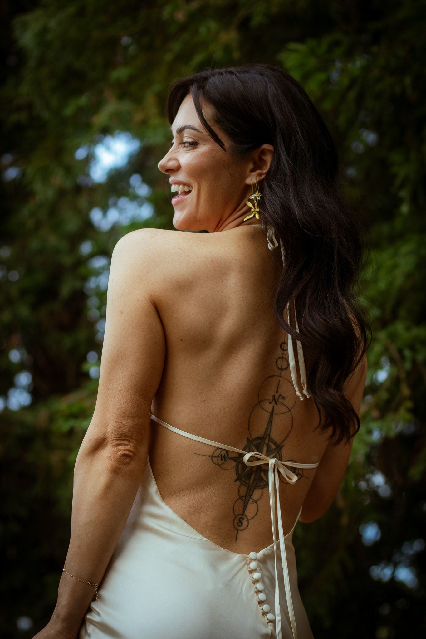 Back view of a wedding dress with delicate tie details and exposed shoulders.