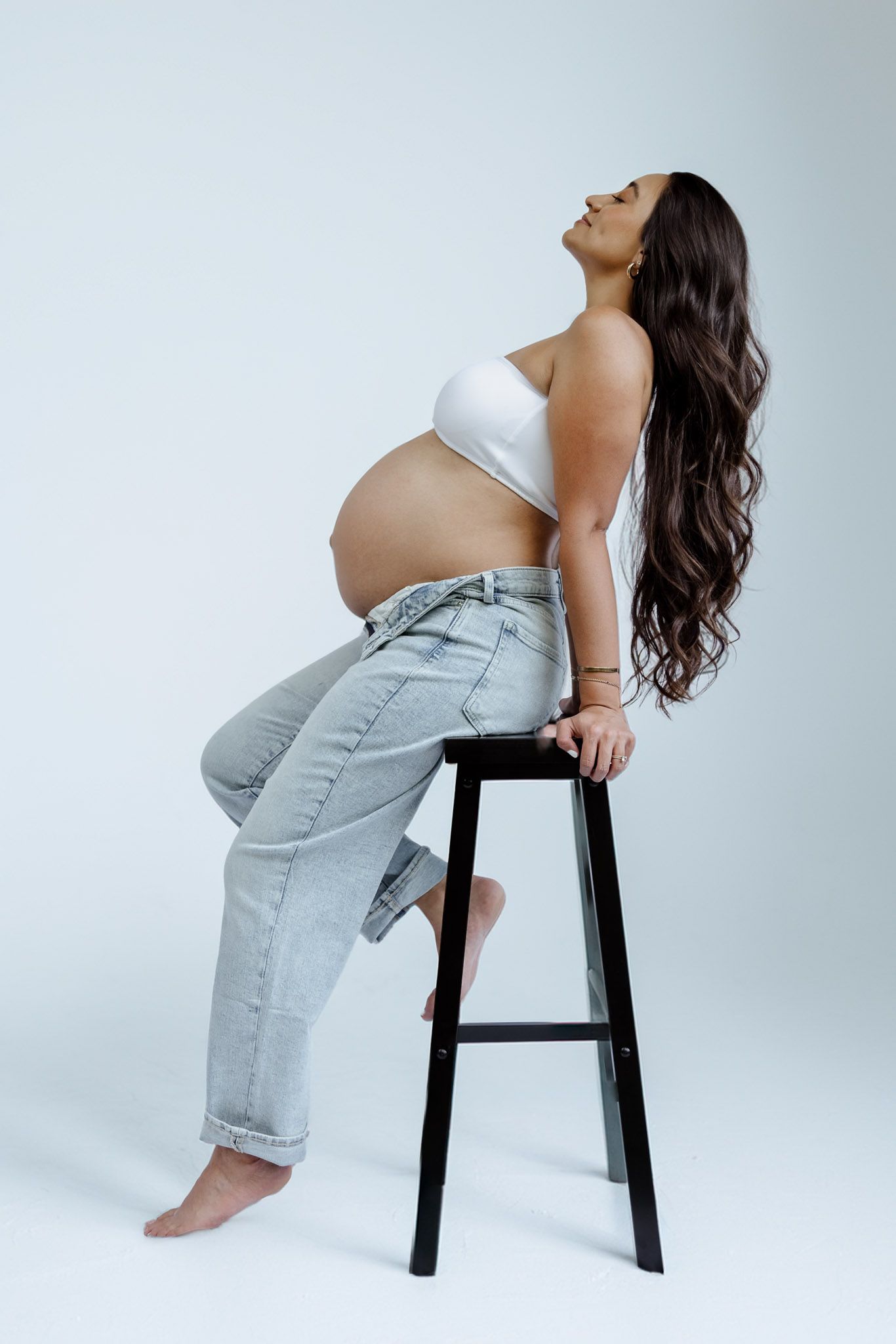 A series of artistic poses on a black stool against a white backdrop showcasing movement and form.