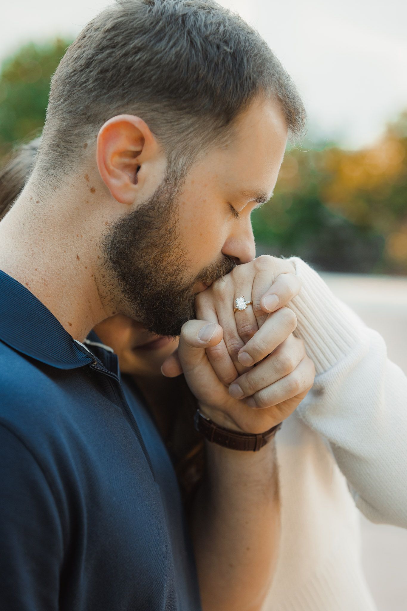A romantic moment captured in a series of photos showing a gentle kiss on the hand against an autumn background.