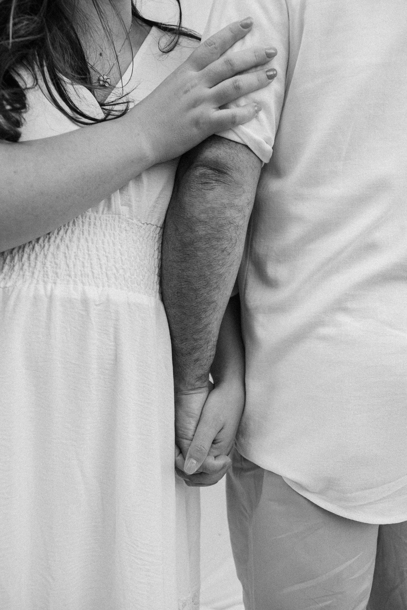 Intimate close-up of couple in white attire embracing.