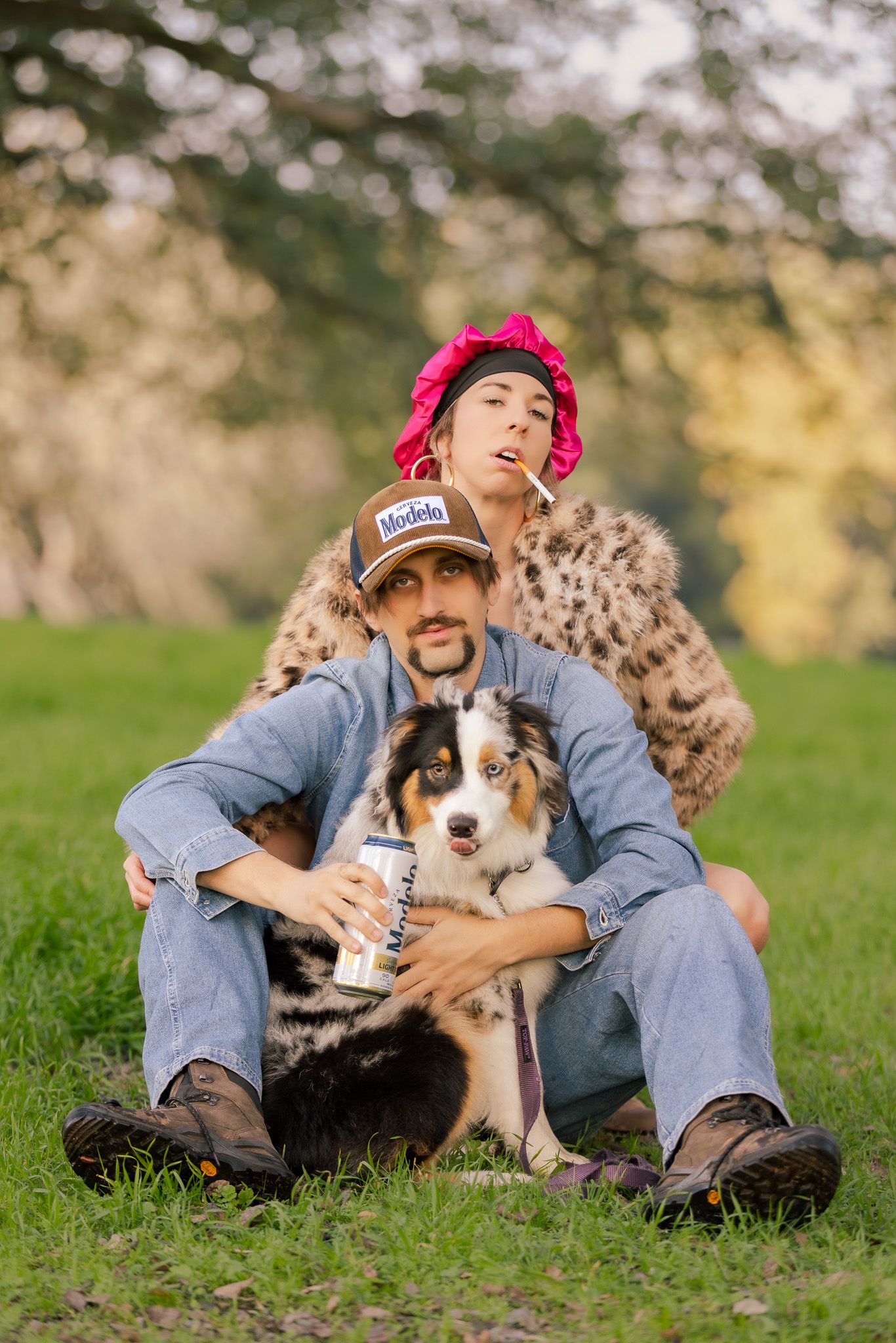 Australian shepherd puppy cuddling with owner on grassy lawn during golden hour sunset.