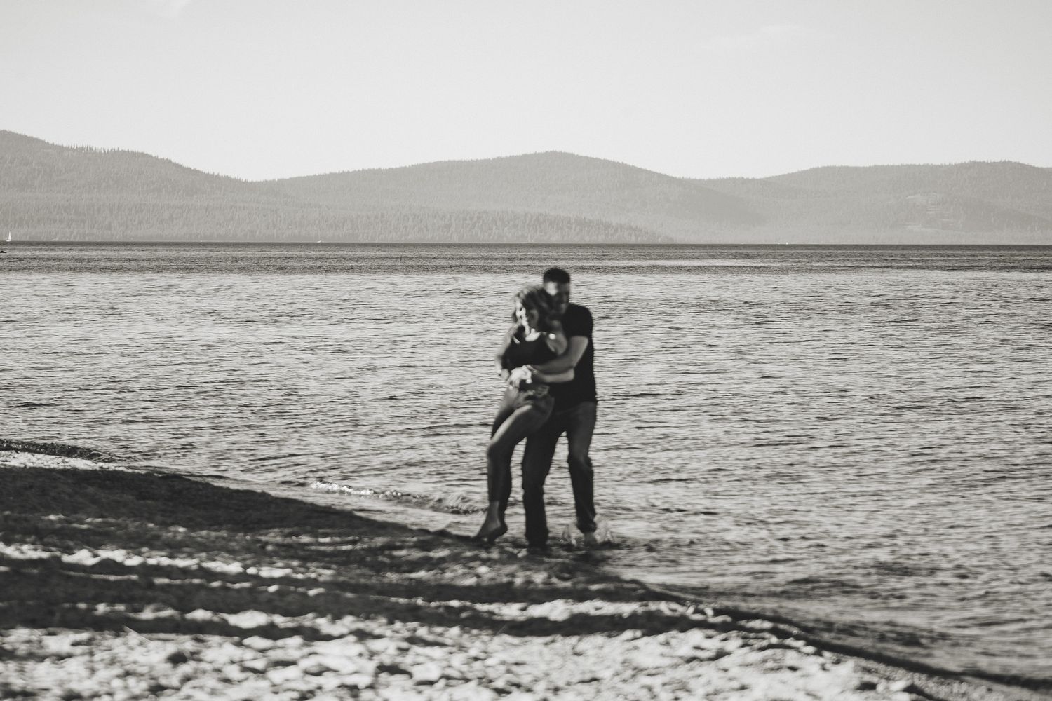 A black and white sequence of images showing a person walking along a rocky beach shoreline at low tide.