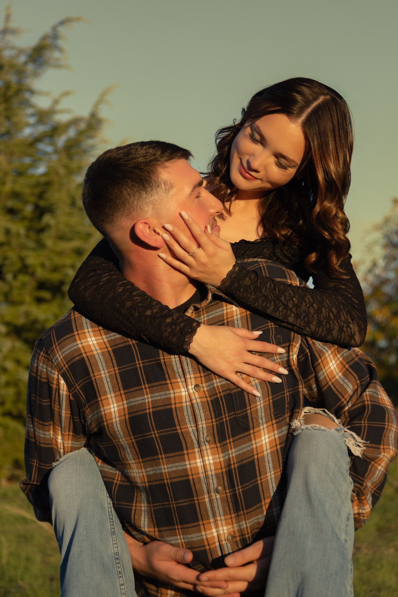 Couple sharing an intimate embrace outdoors during golden hour.