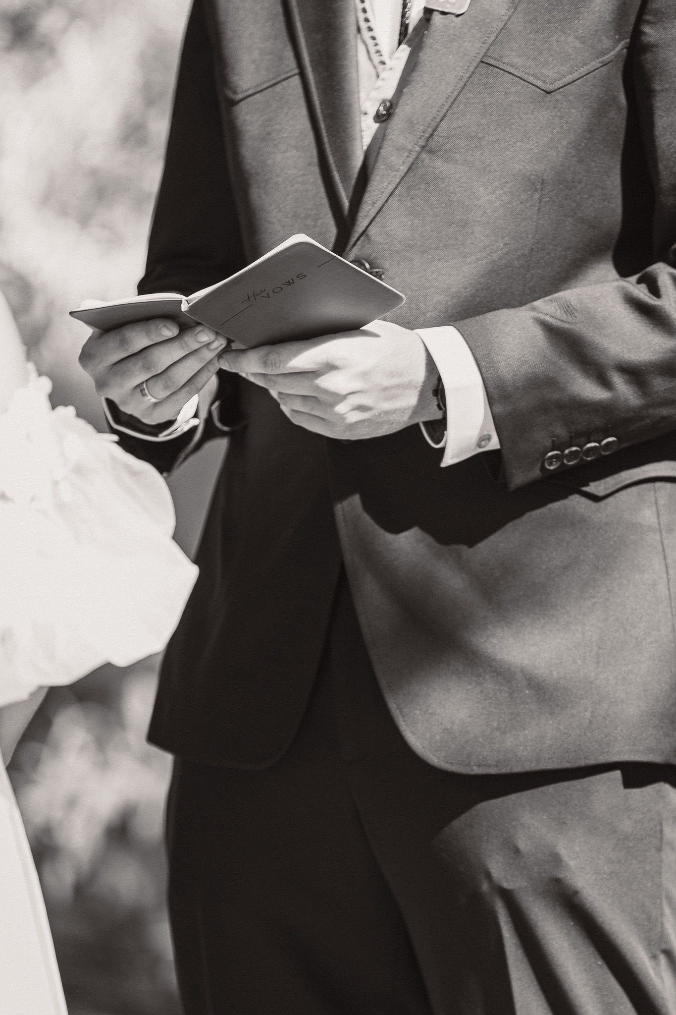 Close-up details of gray suits and formal attire at a wedding ceremony.