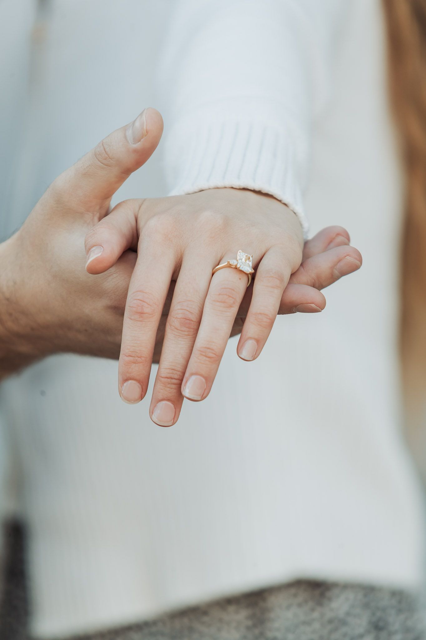 Close-up sequence of hands showing an engagement ring from different angles on a white background.