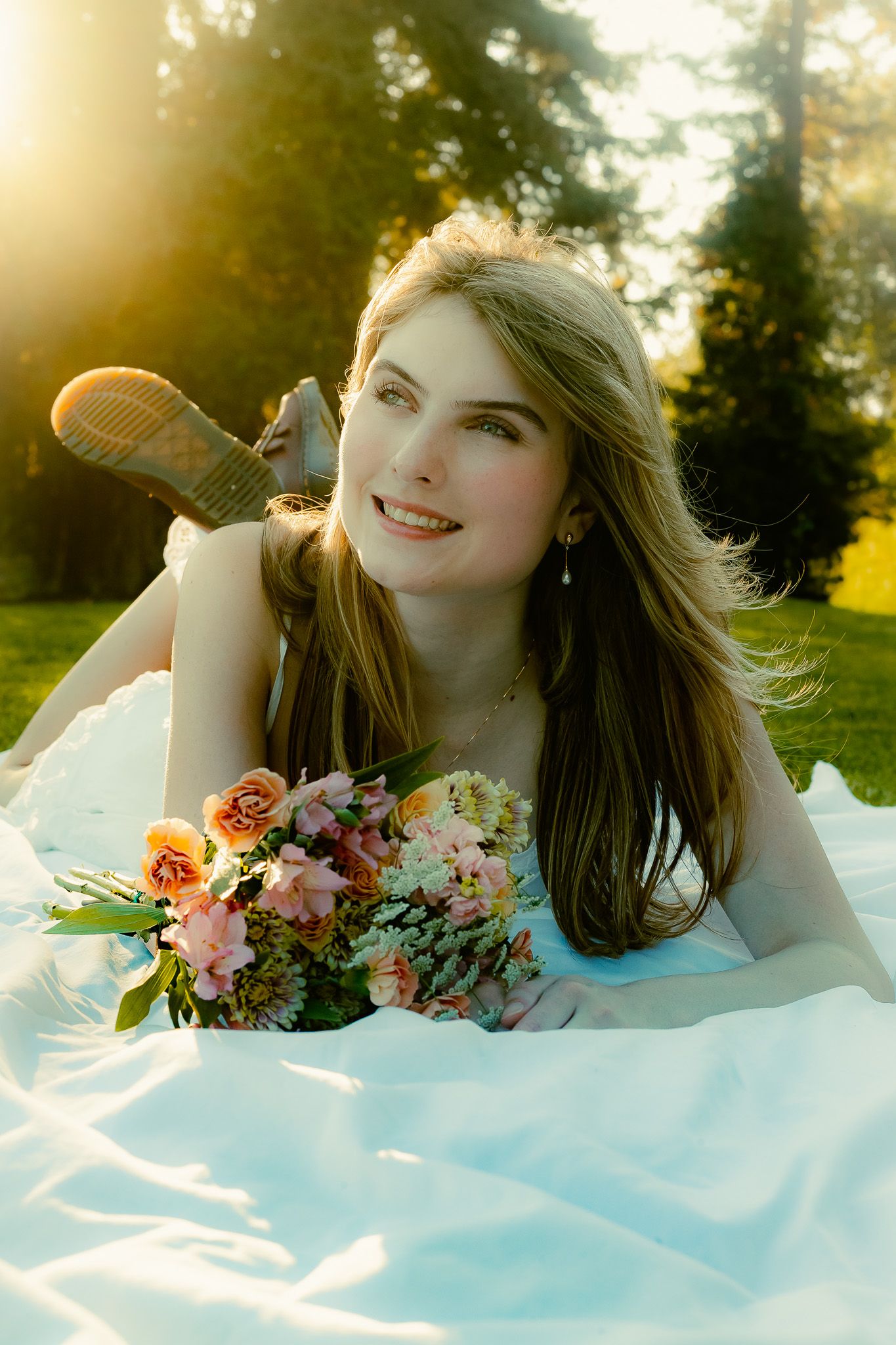A dreamy bridal portrait series with a flowing white dress and pink floral bouquet captured in golden sunlight.