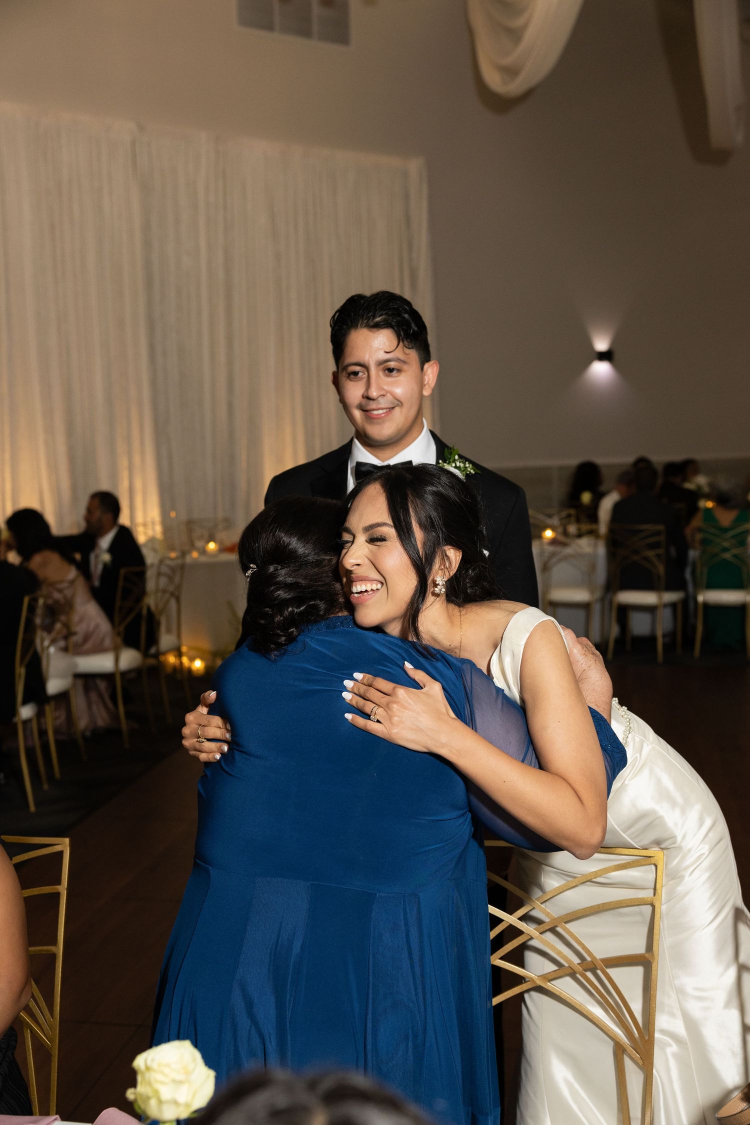 Wedding reception with guests sharing warm embraces and celebrations.