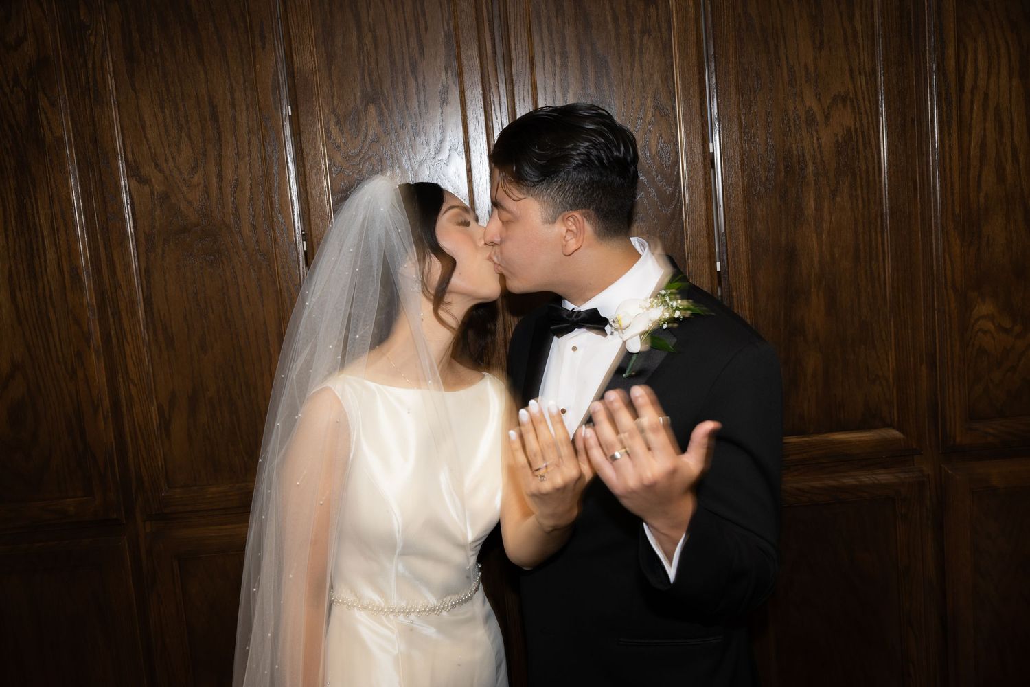 Intimate wedding moment with bride in white gown and groom in black tuxedo.
