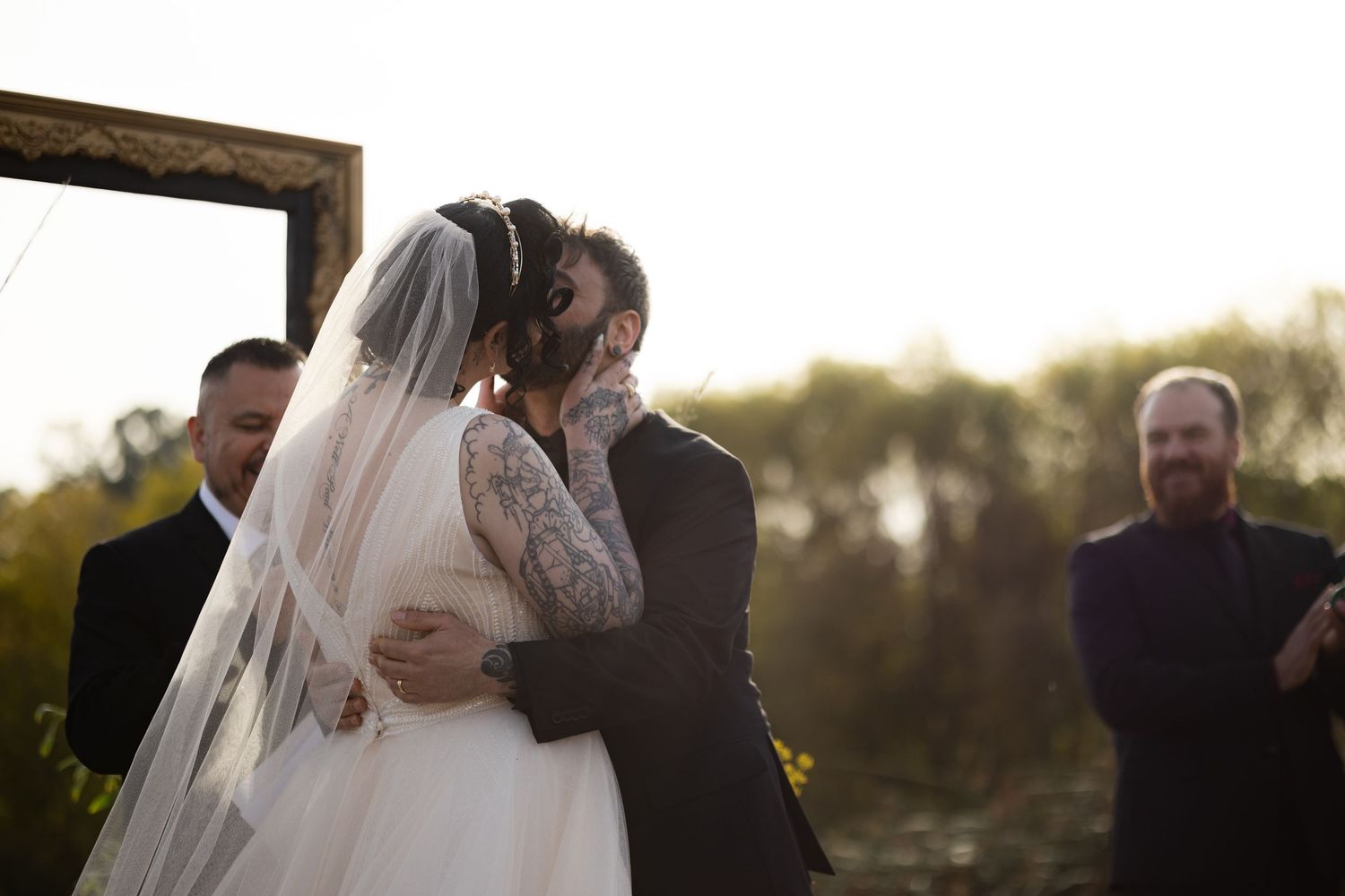 Newlyweds share an intimate moment during sunset at their outdoor wedding ceremony.
