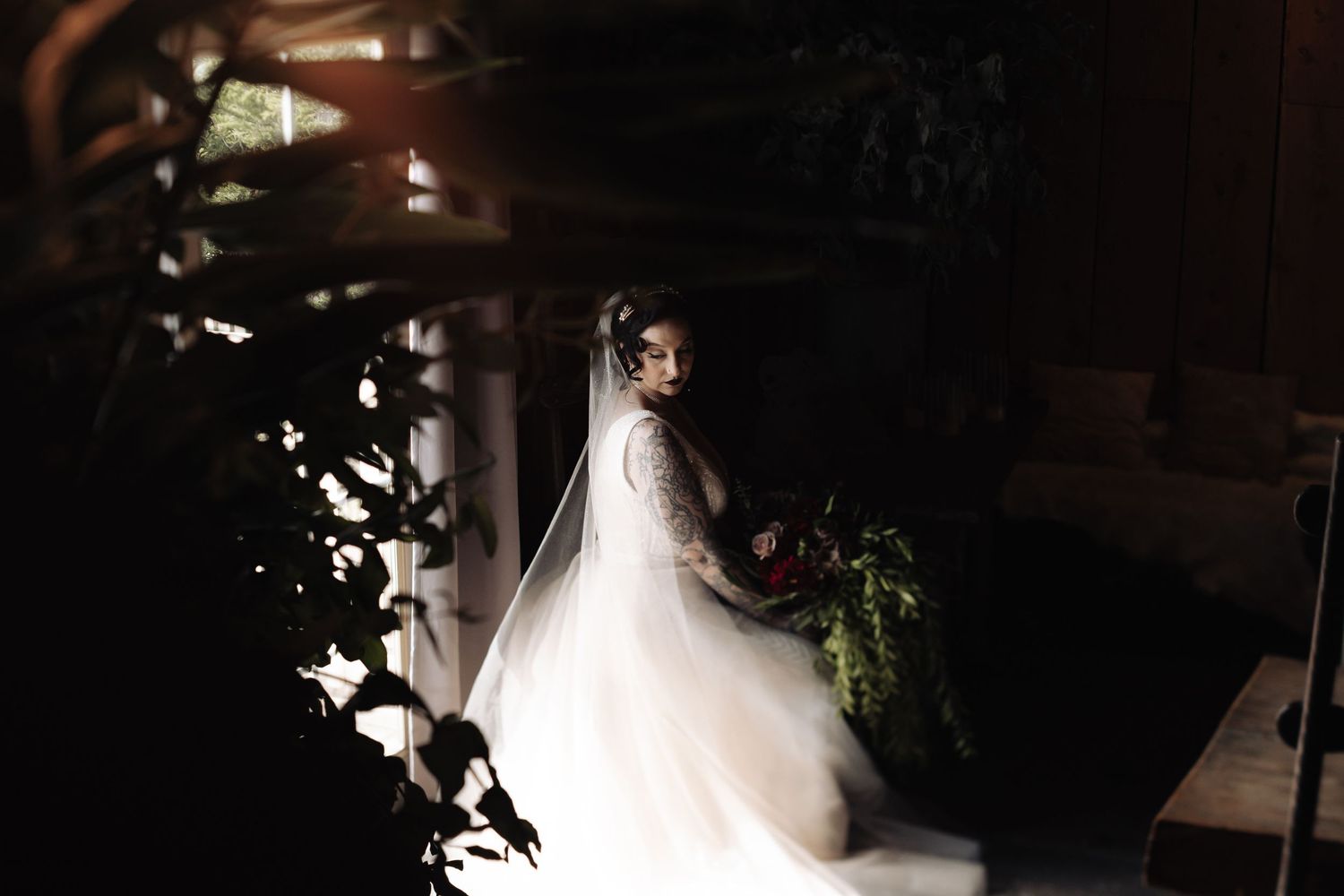Ethereal silhouettes of a wedding couple against a dark background with string lights.