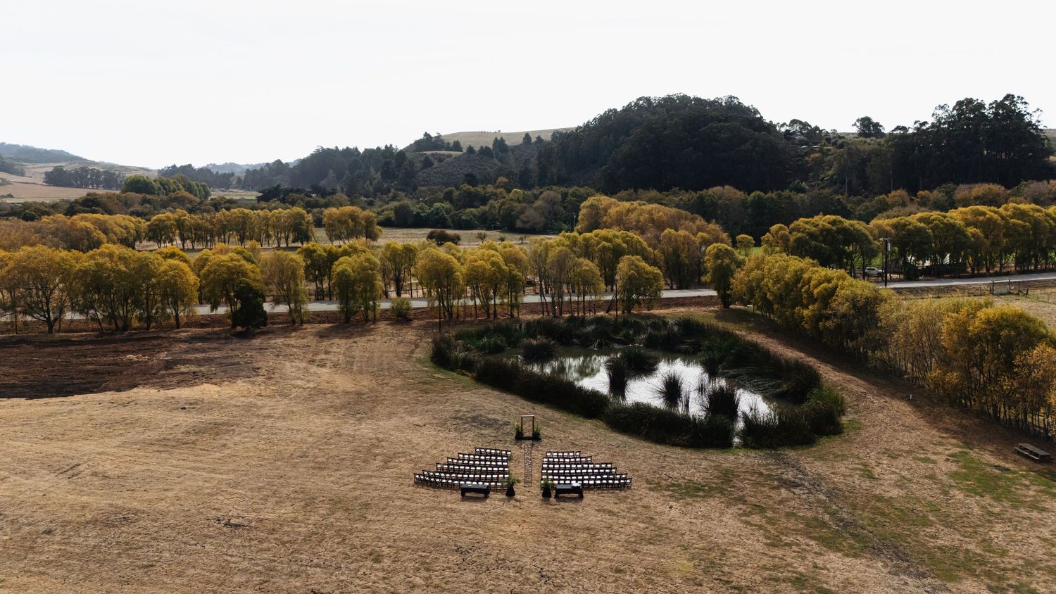 Panoramic landscape view of a rural area with autumn trees and winding paths.