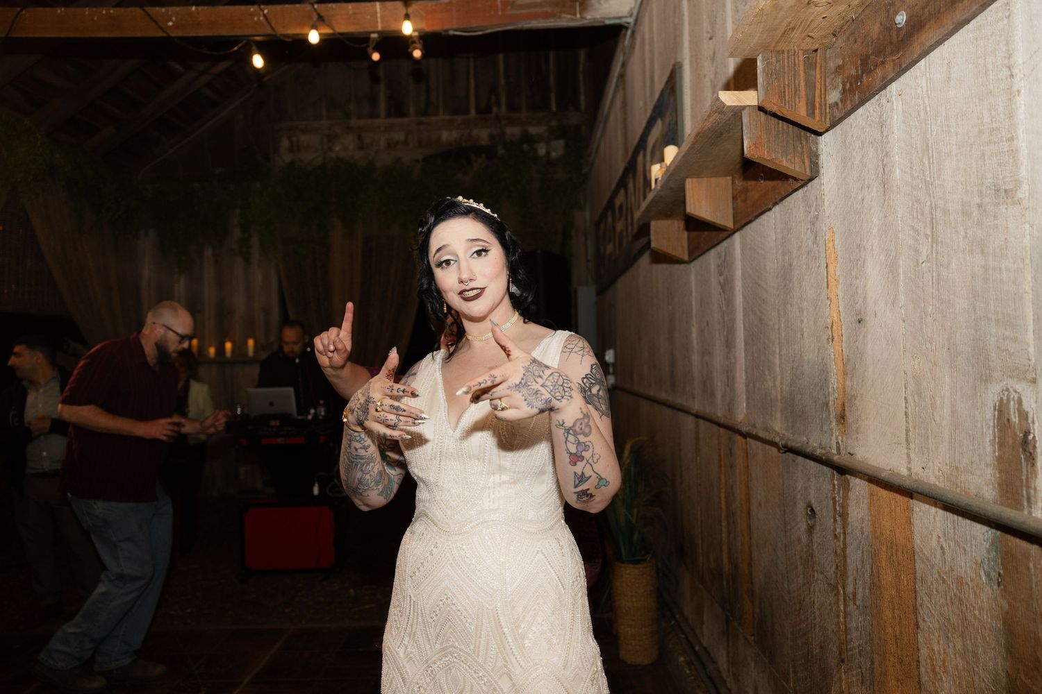 Rustic barn interior with string lights illuminating a lively wedding dance floor.