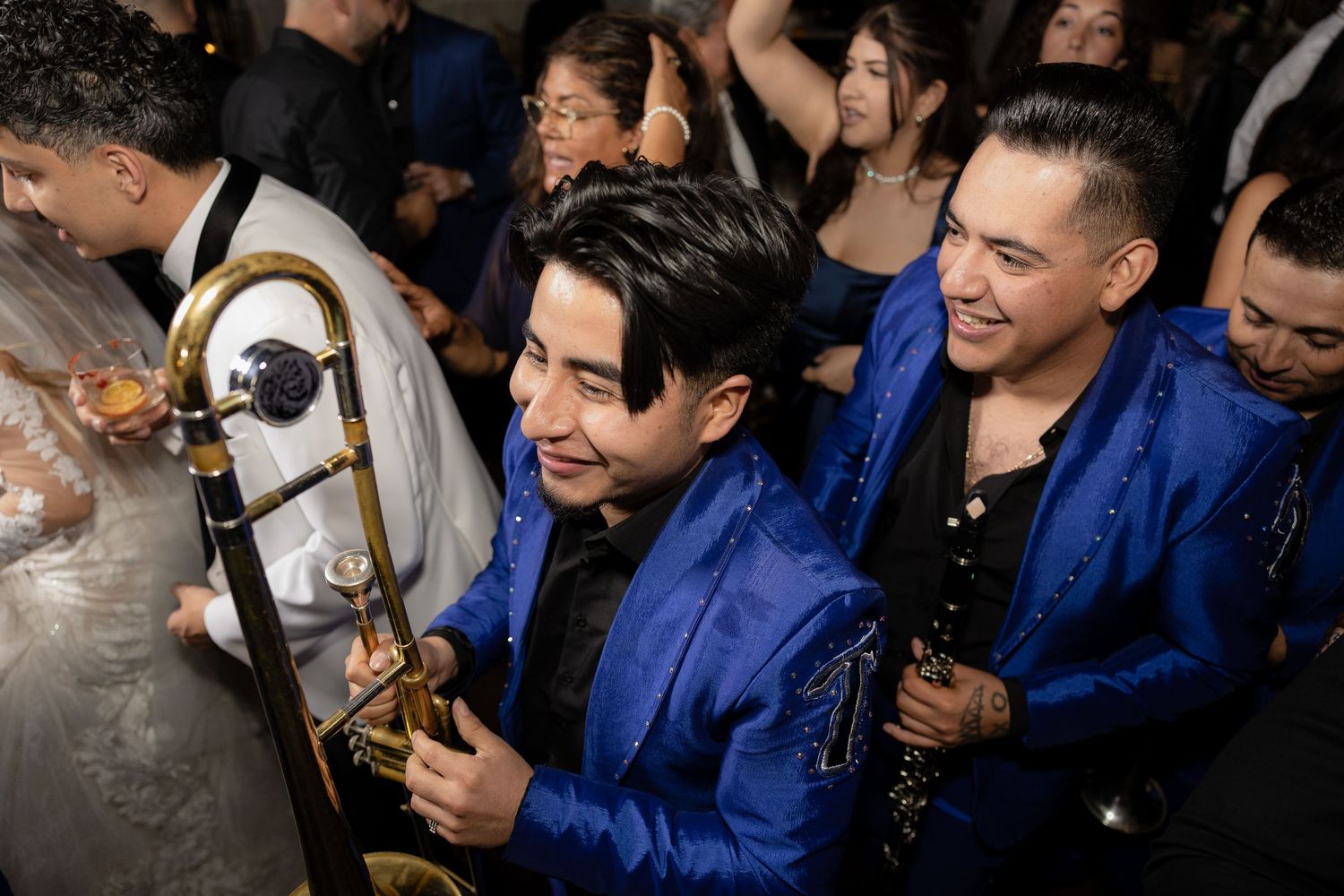Musicians in blue suits performing at a lively wedding reception.