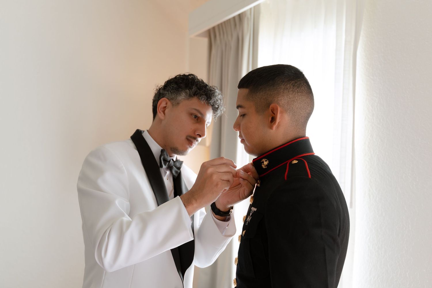 Final adjustments being made to formal wear in a bright room setting.