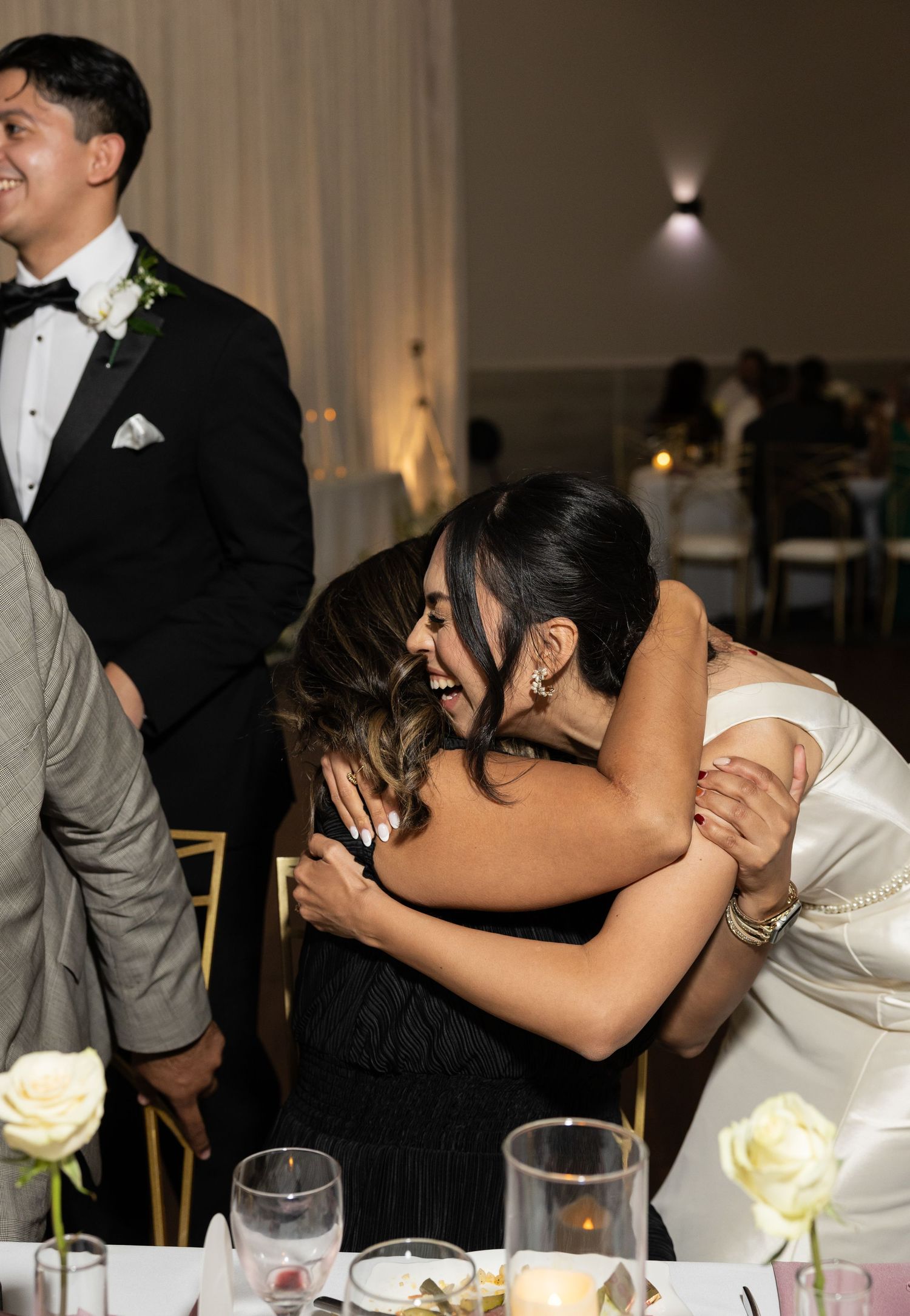 Wedding reception celebration with guests sharing joyful moments at dinner tables.